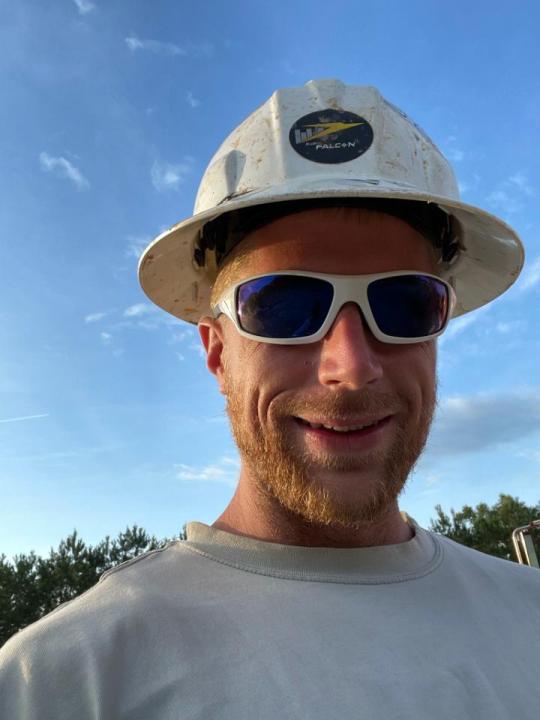 A man in a hard hat and sunglasses