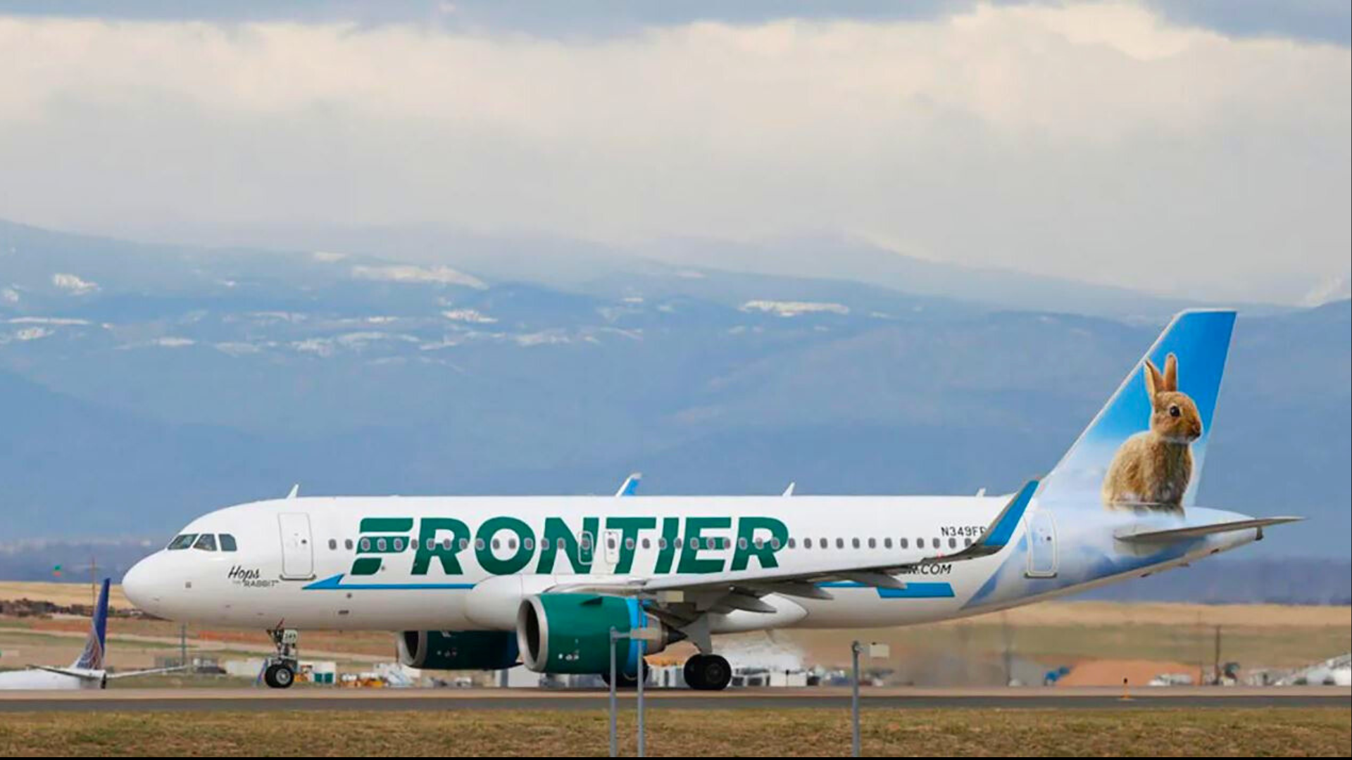 A Frontier Airlines jetliner taxis to a runway to take off from Denver International Airport.