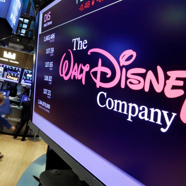 FILE - The Walt Disney Co. logo appears on a screen above the floor of the New York Stock Exchange, Aug. 8, 2017. (AP Photo/Richard Drew, File)