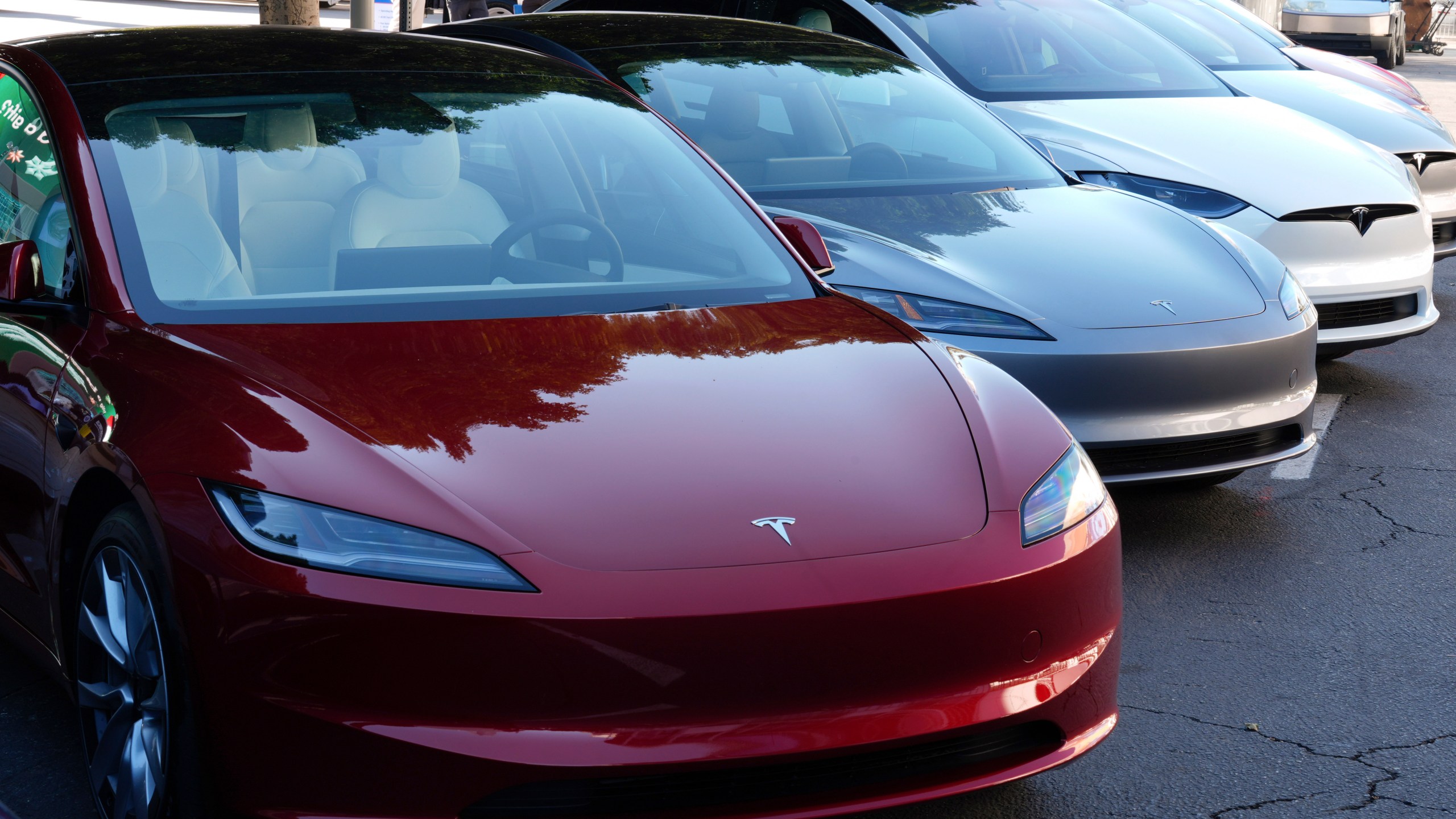 Tesla vehicles are displayed at an auto show