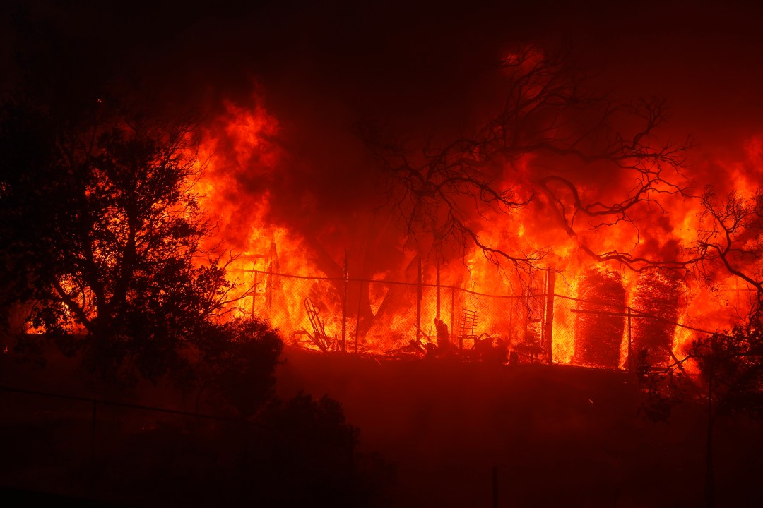 A structure burning in the Palisades Fire