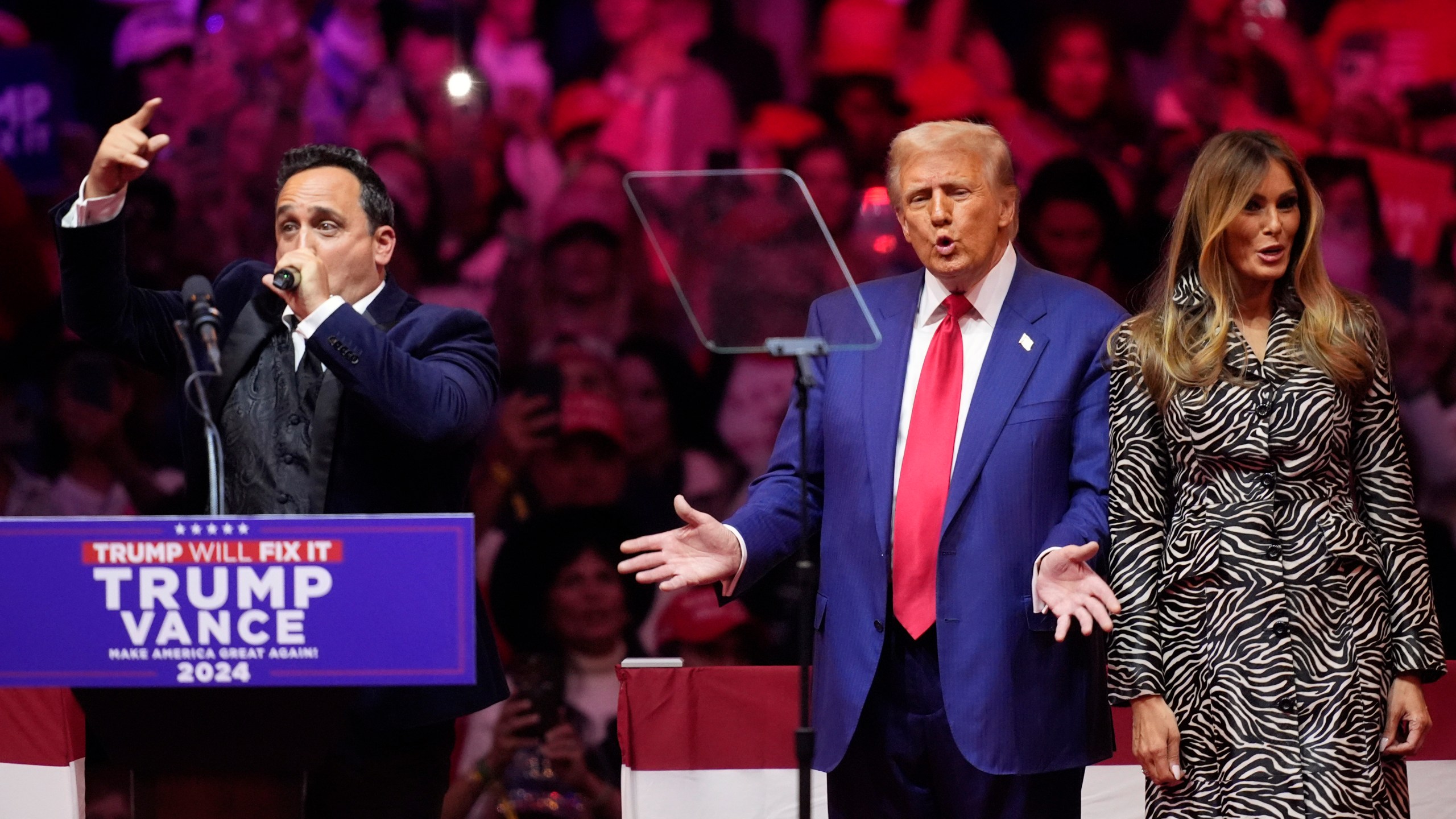 FILE - Republican presidential nominee former President Donald Trump, center, and former first lady Melania Trump, right, listen to opera singer Christopher Macchio at a campaign rally at Madison Square Garden, Oct. 27, 2024, in New York. (AP Photo/Evan Vucci, File)