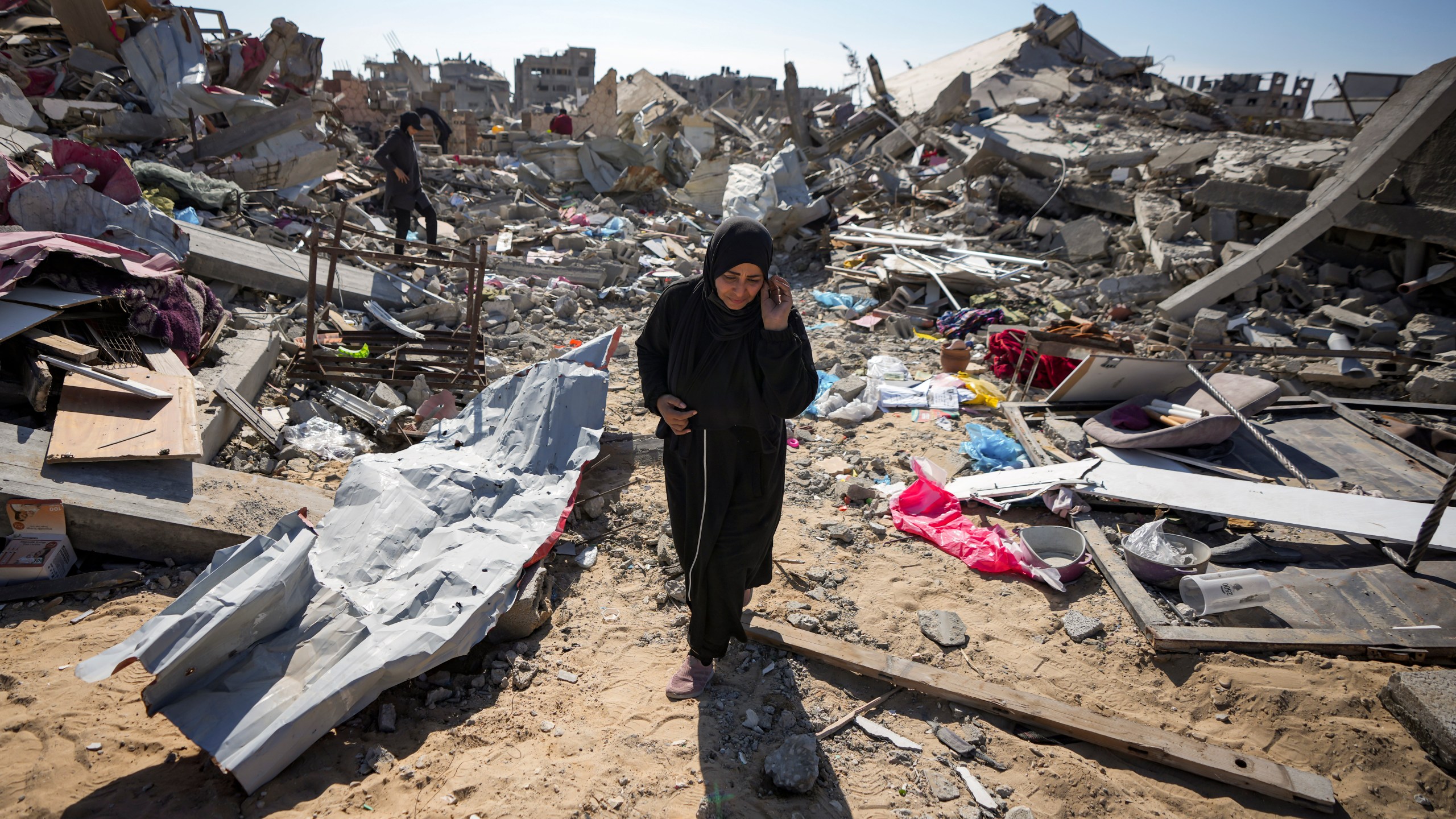 Manual Aslim walks through the rubble of her destroyed home, in Rafah, southern Gaza Strip, Tuesday, Jan. 21, 2025, days after the ceasefire deal between Israel and Hamas came into effect. (AP Photo/Abdel Kareem Hana)