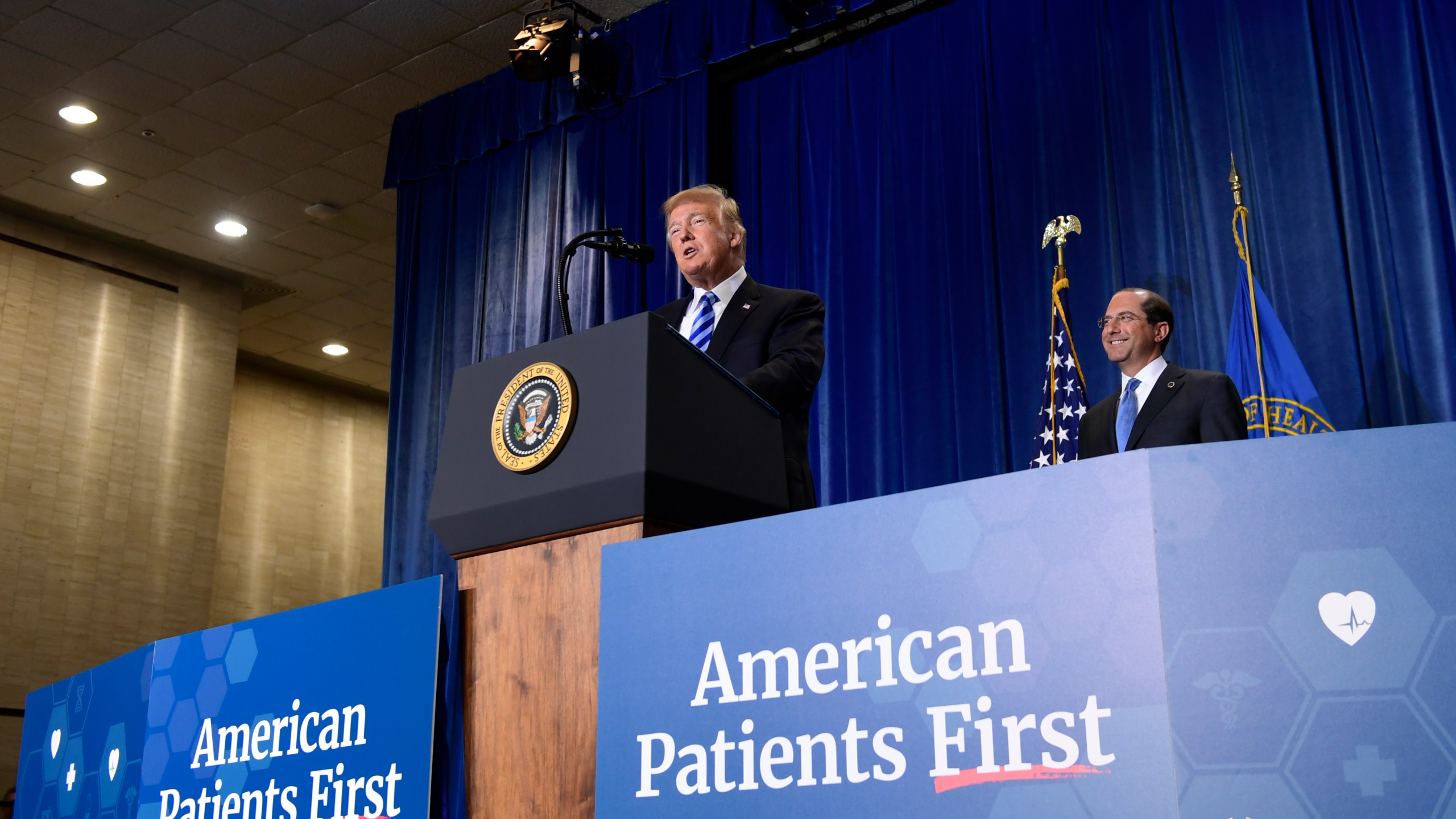 FILE - President Donald Trump talks about drug prices during a visit to the Department of Health and Human Services in Washington, Oct. 25, 2018. HHS Secretary Alex Azar listens at right. (AP Photo/Susan Walsh, file)