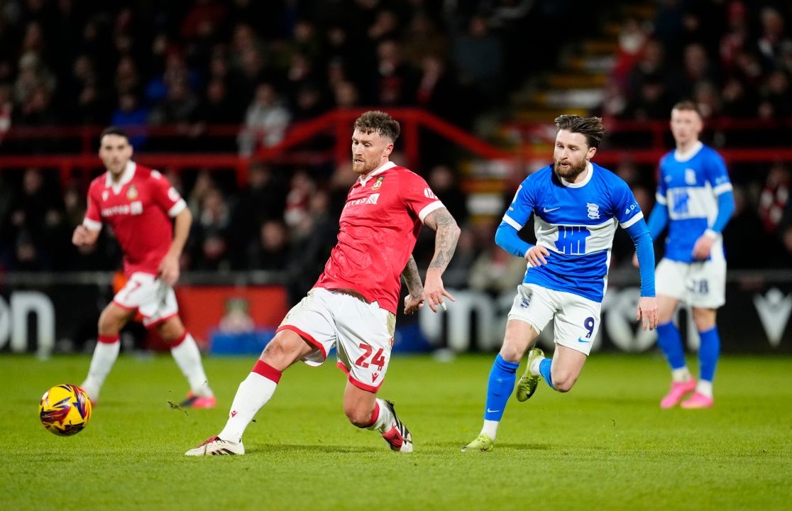 Wrexham's Dan Scarr, foreground controls the ball past Birmingham City's Alfie May, center right, during the English Football League One soccer match between Wrexham and Birmingham City at the SToK Racecourse, in Wrexham, Wales, Thursday, Jan. 23, 2025. (Nick Potts/PA via AP)