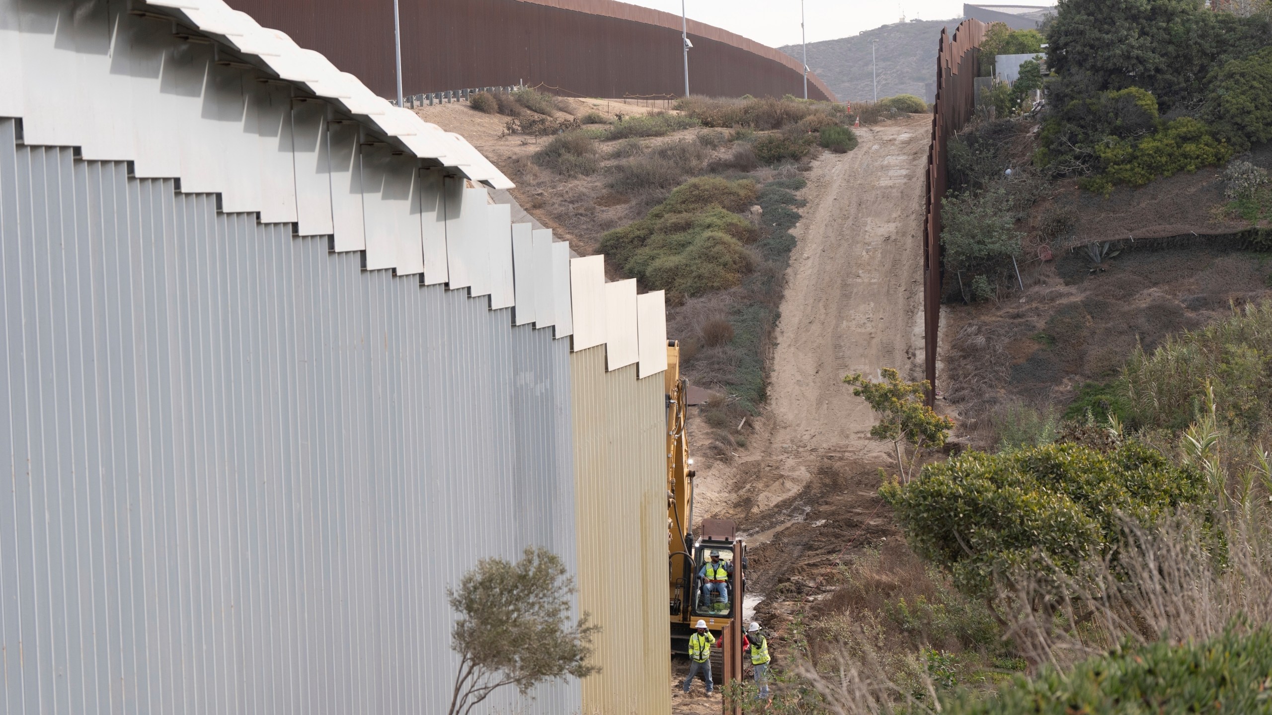 FILE - Construction crews replace sections of one of two border walls separating Mexico from the United States, Wednesday, Jan. 22, 2025, in Tijuana, Mexico. (AP Photo/Gregory Bull, File)
