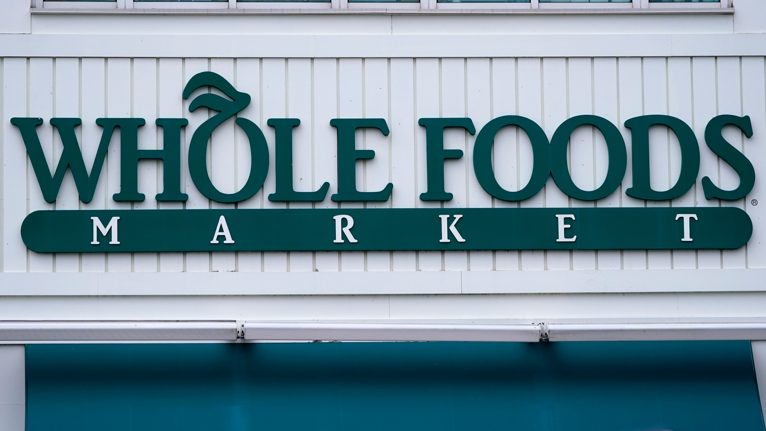 FILE - The Whole Foods Market logo is shown on the front of a store, July 14, 2021, in Cambridge, Mass. (AP Photo/Charles Krupa, File)