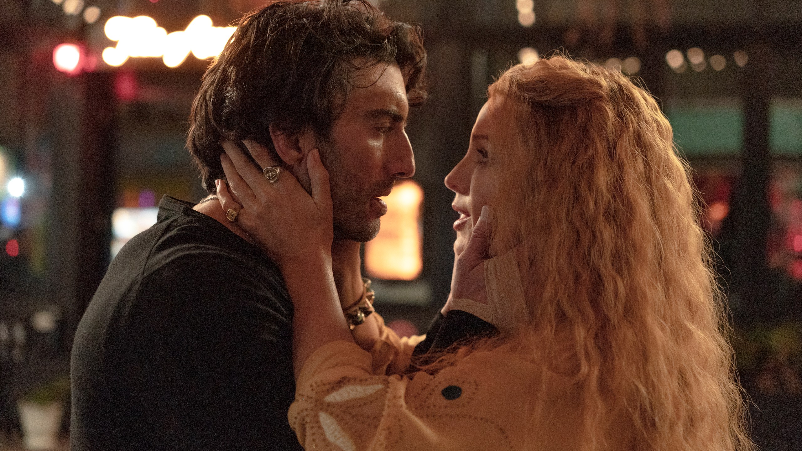 Justin Baldoni and Blake Lively caress each other in a movie scene