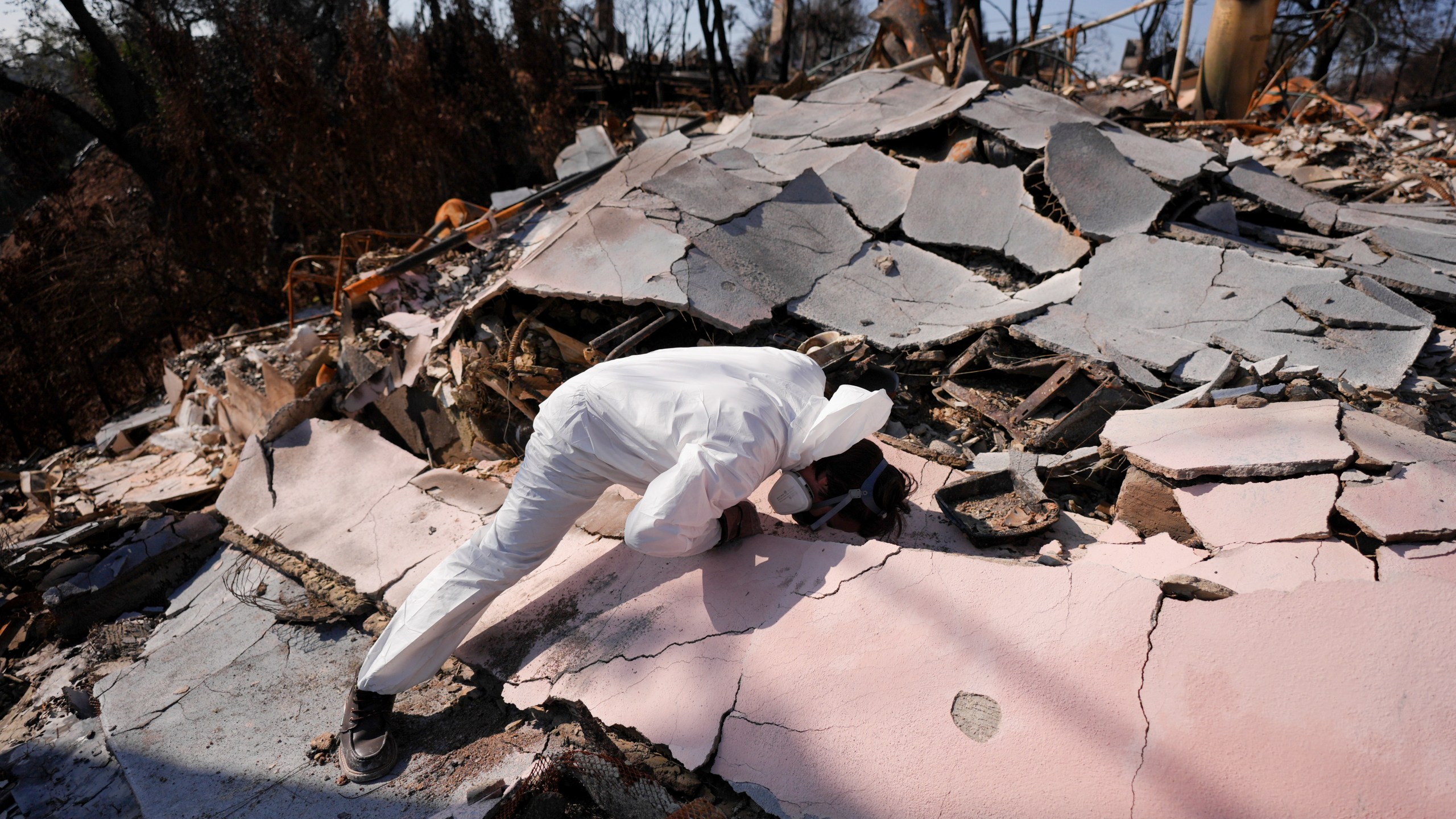 John Borbone searches through his fire-ravaged property after the Palisades Fire in the Pacific Palisades neighborhood of Los Angeles, Tuesday, Jan. 28, 2025. (AP Photo/Jae C. Hong)