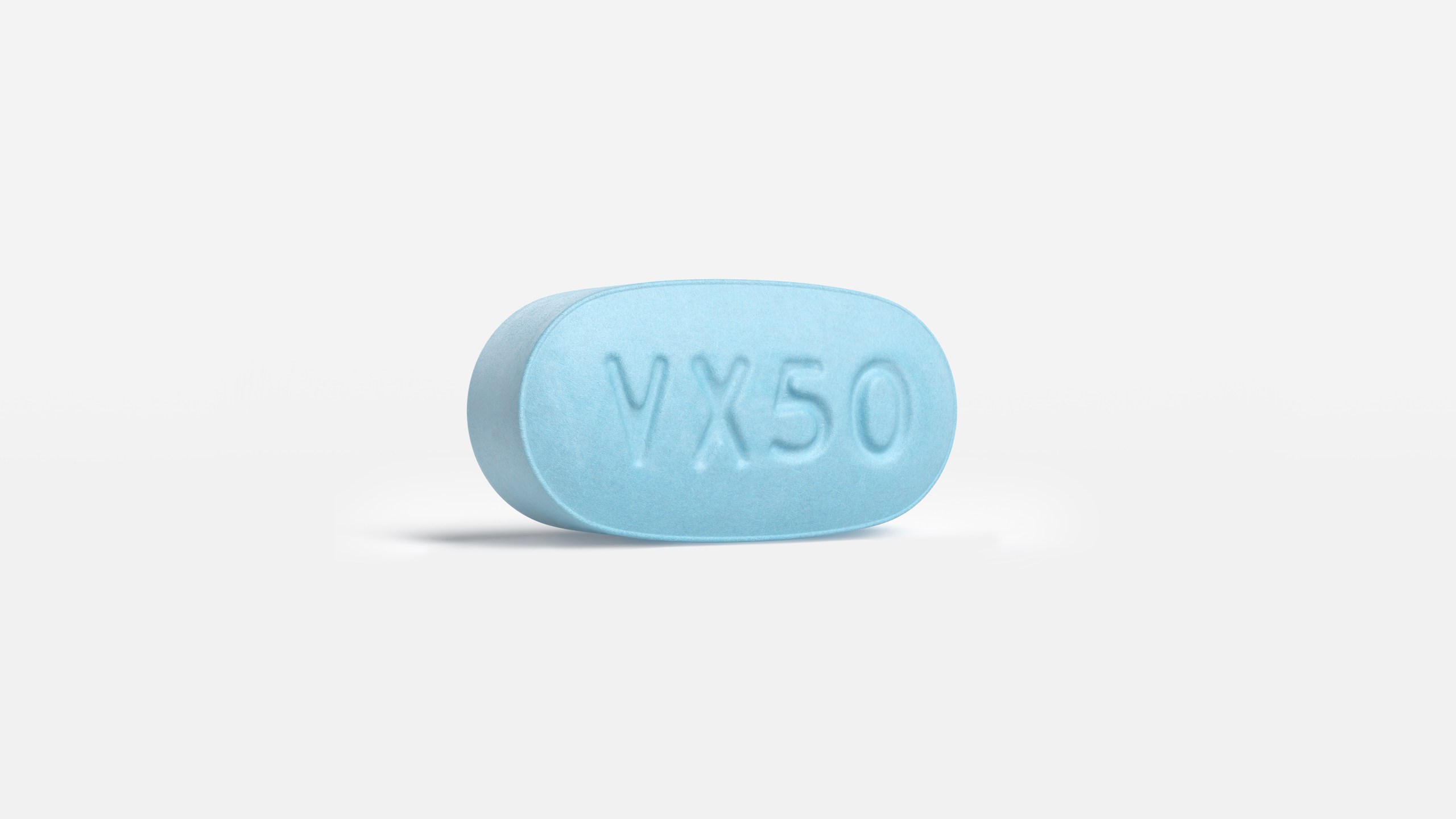 A tablet of the JOURNAVX (suzetrigine) medication — a round, blue pill.