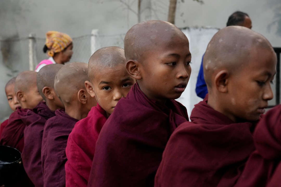 Buddhist novice monks line up to collect their morning alms from Buddhist devotees Saturday, Feb. 1, 2025, in Naypyitaw, Myanmar. (AP Photo/Aung Shine Oo)