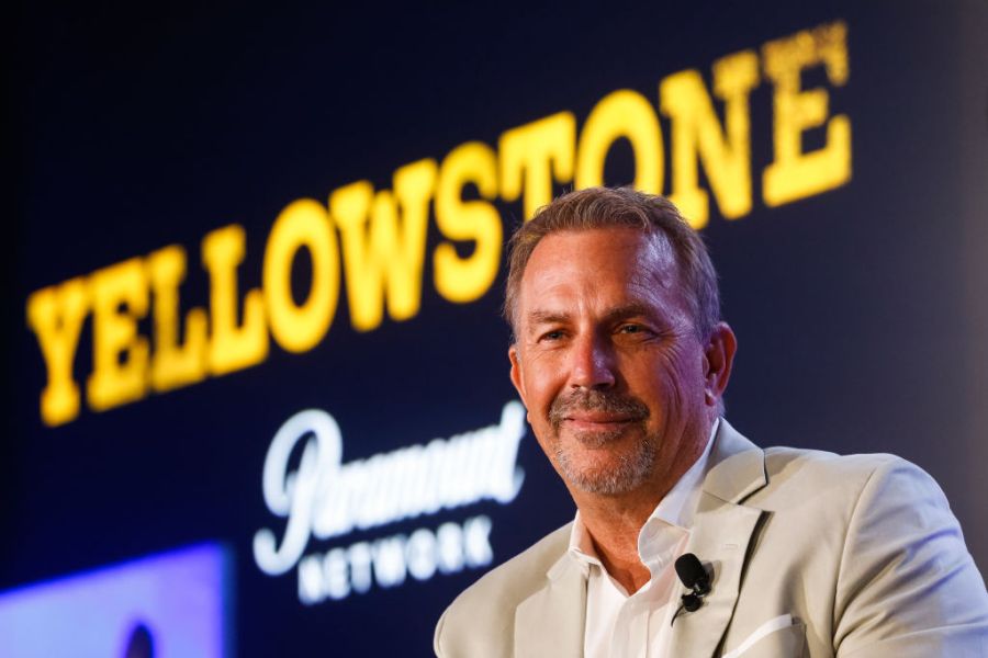 Kevin Costner in front of "Yellowstone" sign