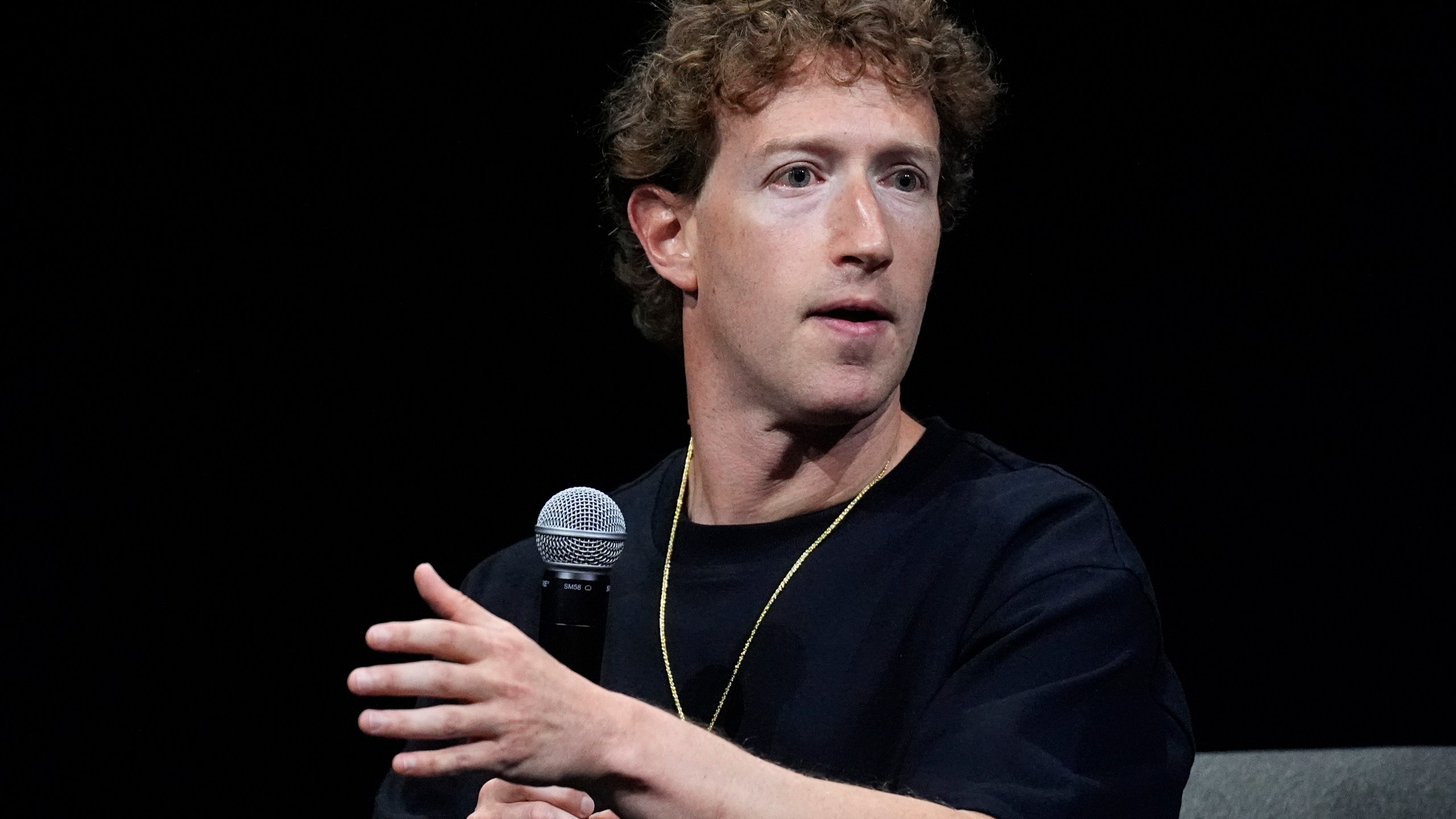 Mark Zuckerberg gestures while speaking onstage