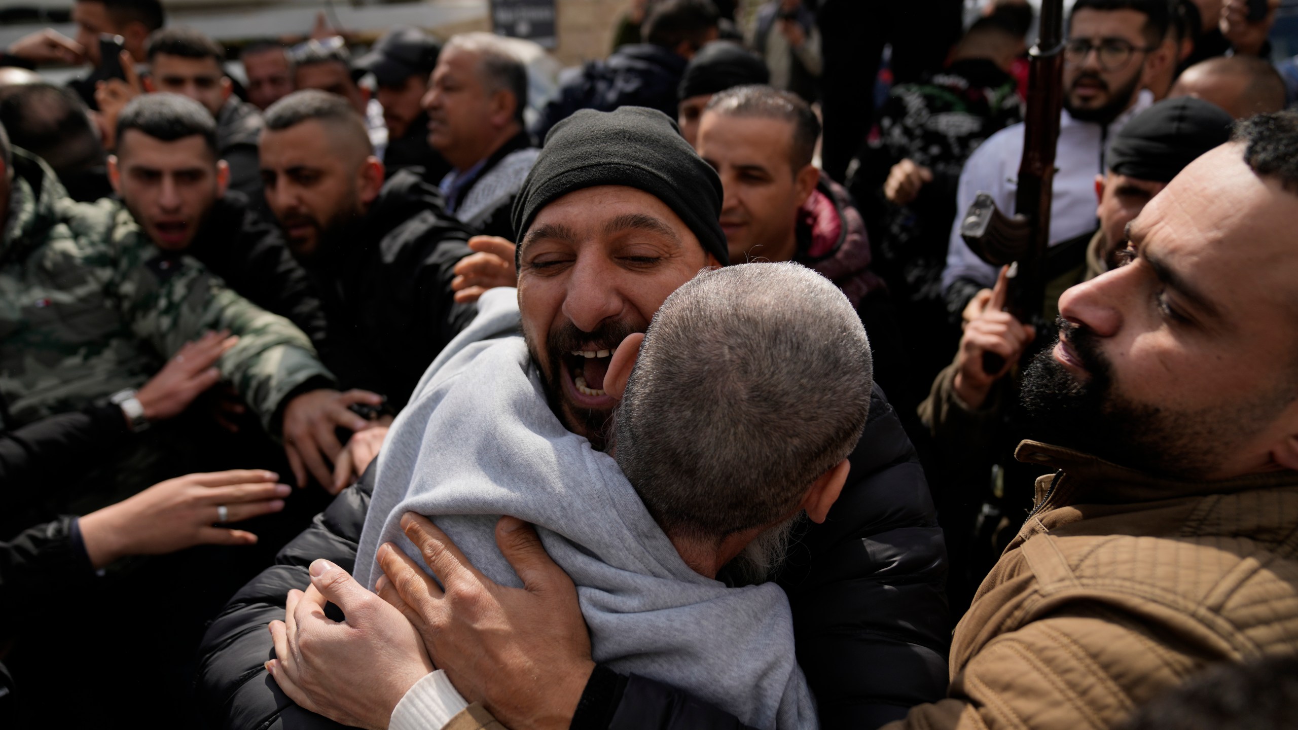 Palestinian prisoners are greeted as they exit a Red Cross bus after being released from Israeli prison following a ceasefire agreement between Israel and Hamas, in the West Bank city of Ramallah, Saturday Feb. 1, 2025. (AP Photo/Nasser Nasser)