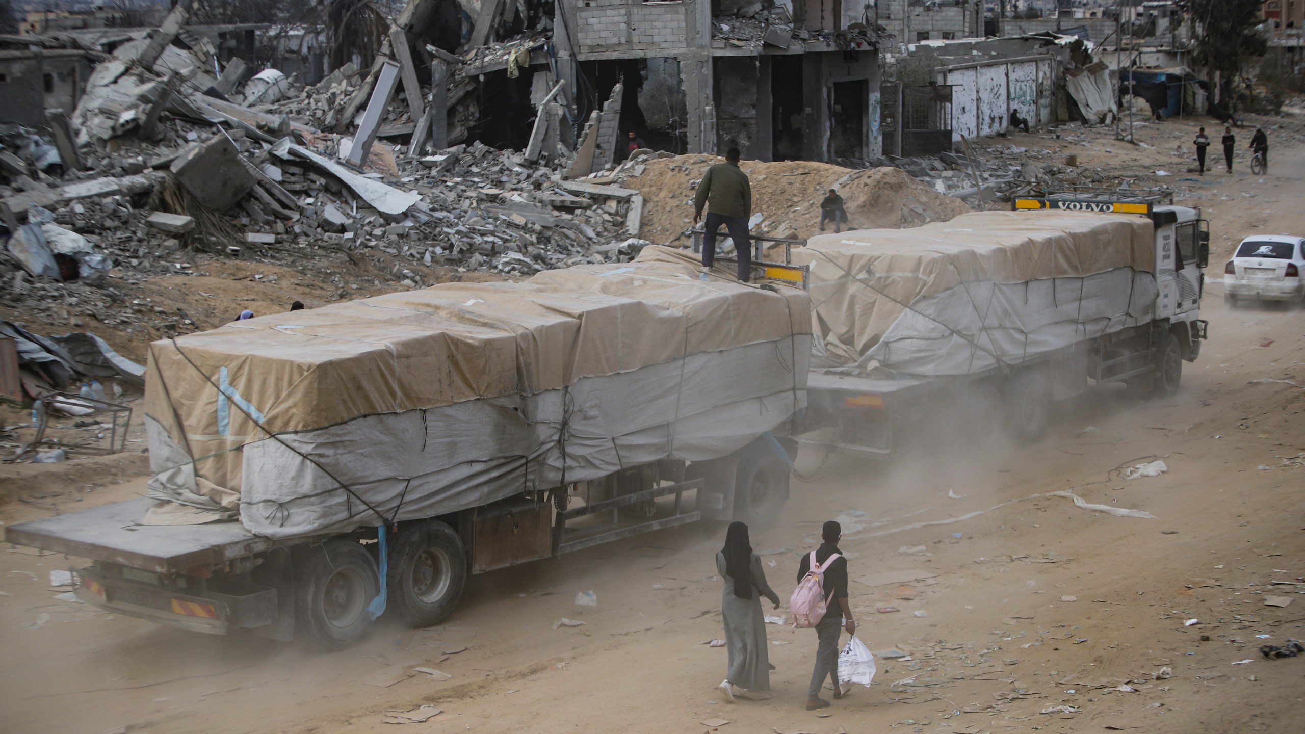Humanitarian aid trucks enter through the Kerem Shalom crossing from Egypt into the Gaza Strip, in Rafah, Wednesday, Jan. 22, 2025, days after the ceasefire deal between Israel and Hamas came into effect. (AP Photo/Jehad Alshrafi)
