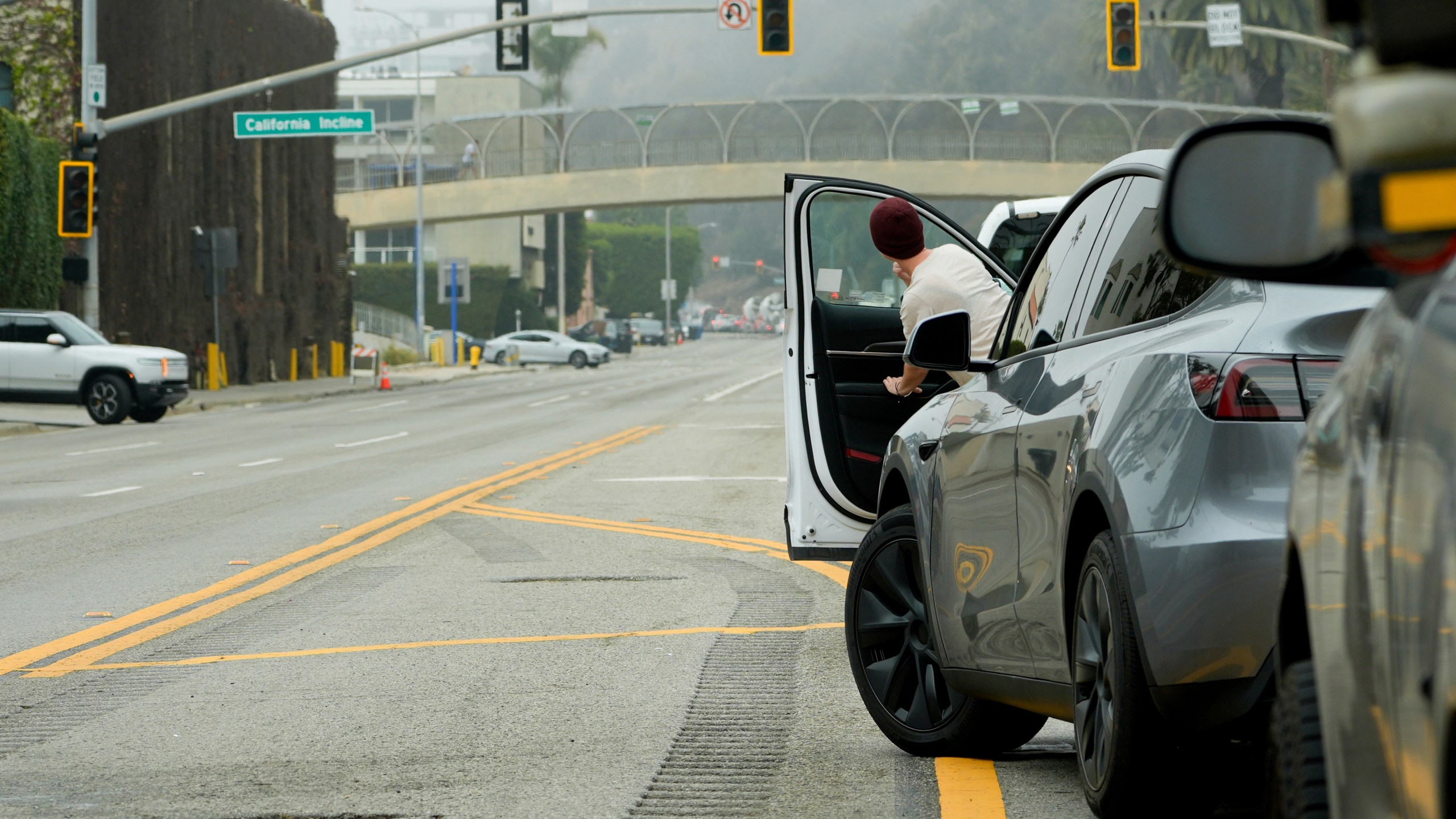 A motorist peeks out of their car as traffic is backed up along Pacific Coast Highway near the Palisades Fire zone Monday, Feb. 3, 2025, in Santa Monica, Calif. (AP Photo/Damian Dovarganes)