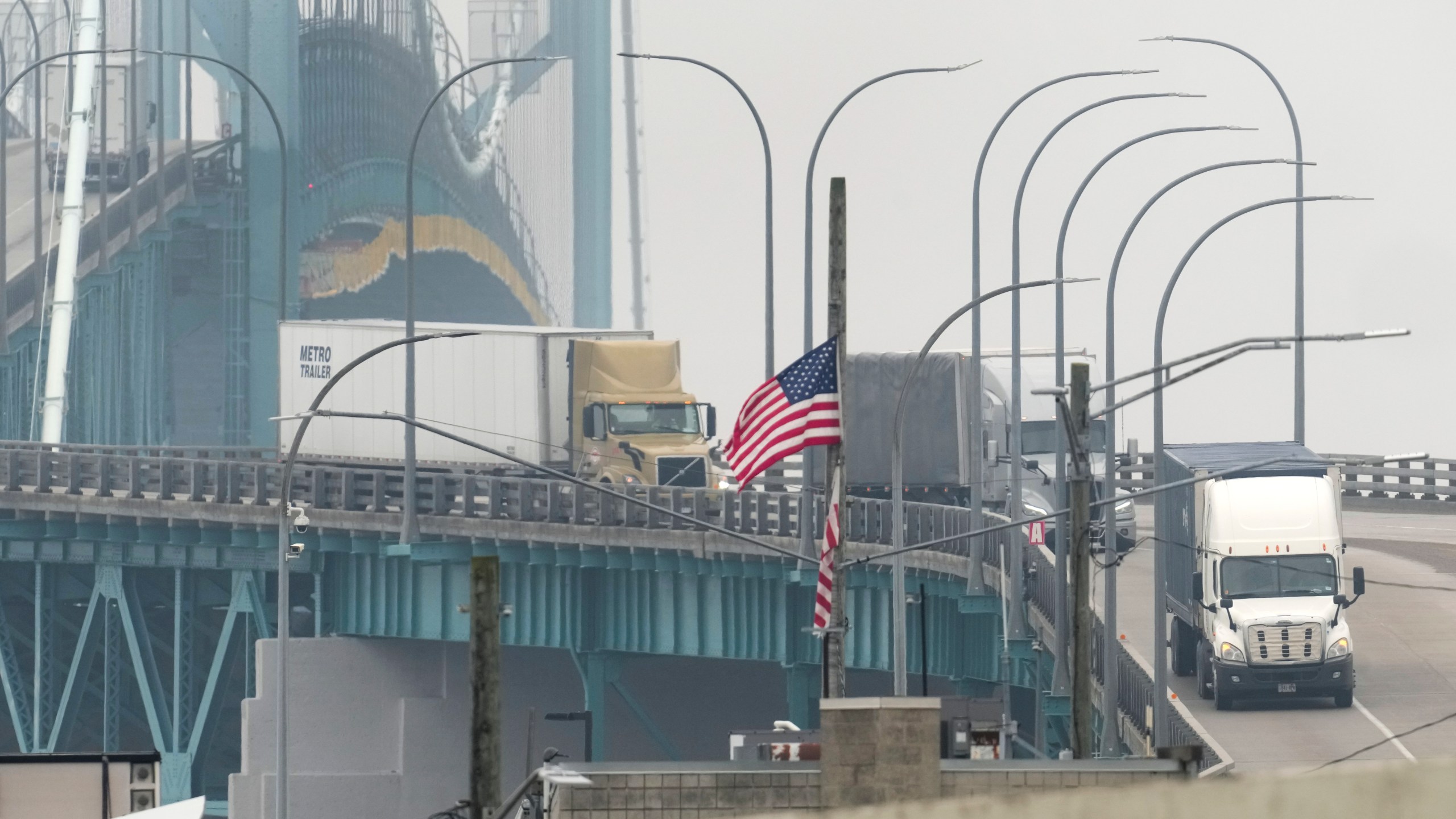Trucks enter into the United States from Ontario, Canada across the Ambassador Bridge, Monday, Feb. 3, 2025, in Detroit. (AP Photo/Paul Sancya)