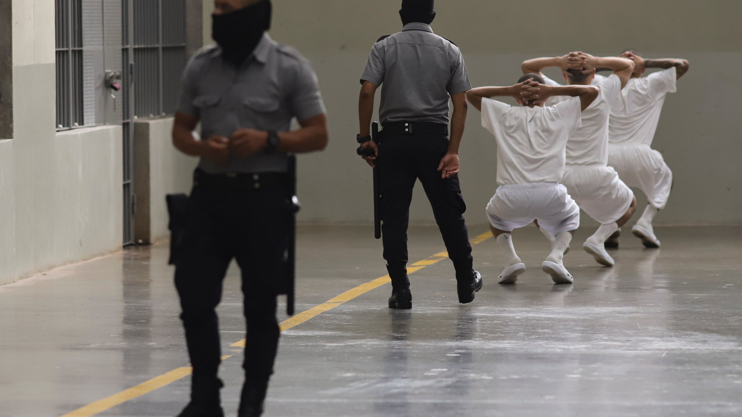Inmates exercise under the watch of prison guards during a press tour of the Terrorism Confinement Center, or CECOT, in Tecololuca, El Salvador, Oct. 12, 2023.