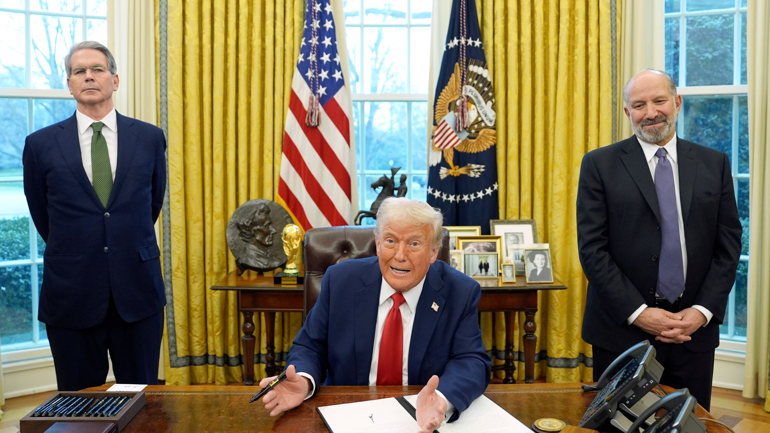 President Donald Trump speaks as Treasury Secretary Scott Bessent, left, and Commerce Secretary nominee Howard Lutnick listen as Trump prepares to sign an executive order in the Oval Office of the White House, Monday, Feb. 3, 2025, in Washington. (AP Photo/Evan Vucci)