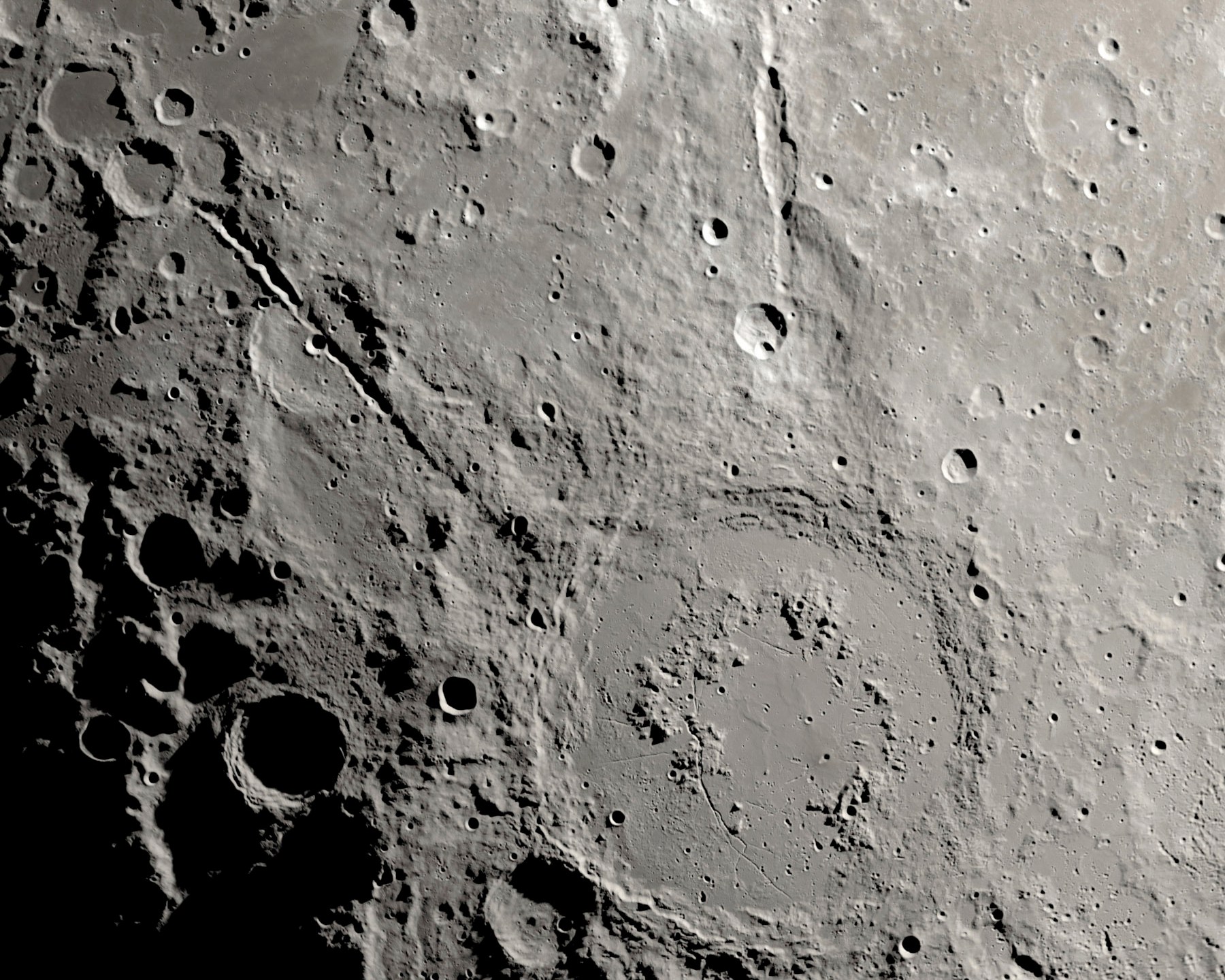 This image provided by NASA shows a view from orbit, looking straight down at the Moon’s surface, where an ancient asteroid strike carved out a pair of grand canyons on the moon’s far side. (Ernie T. Wright/NASA via AP)