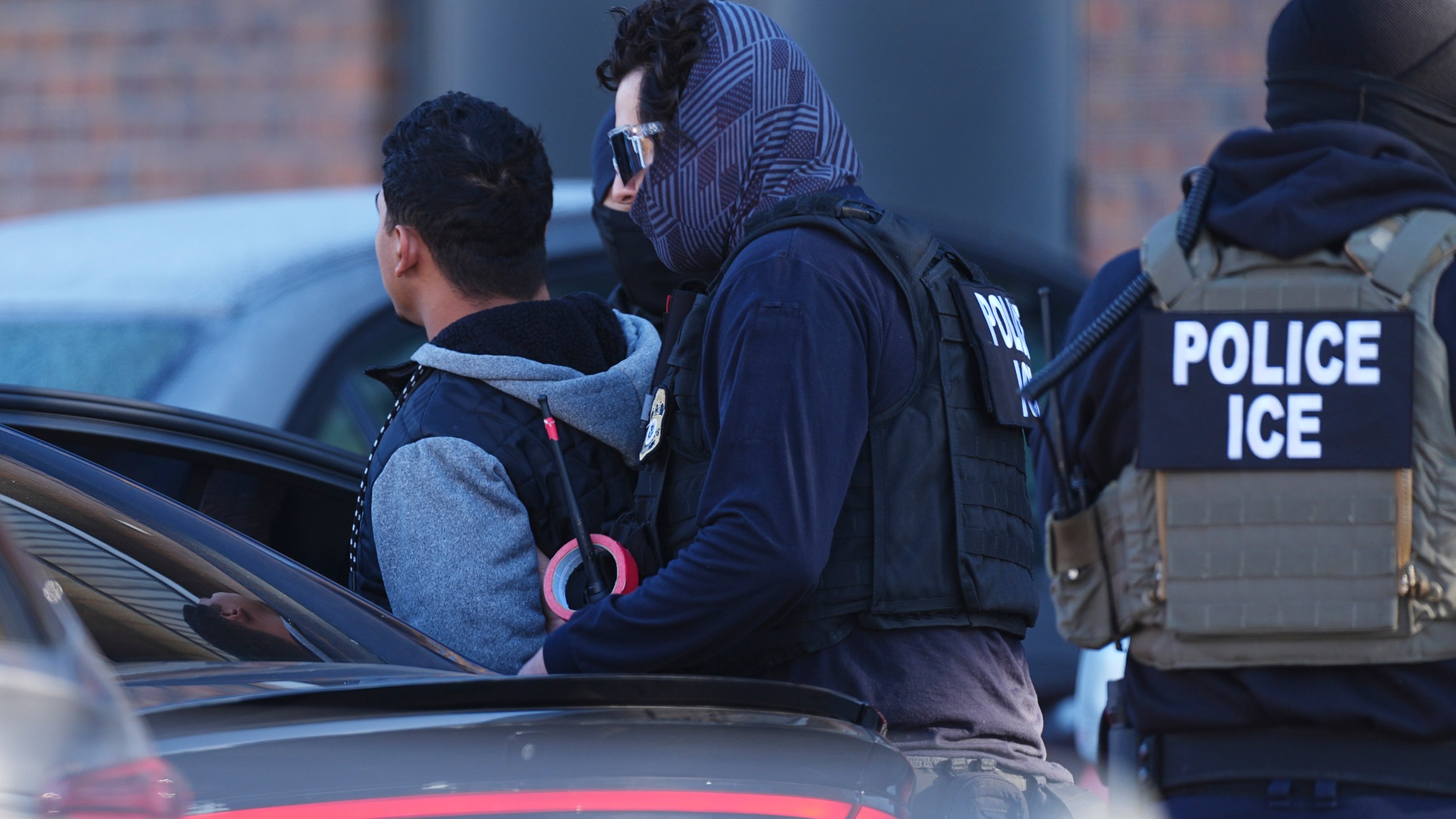 Law officials load a man into a utility vehicle during a raid of an apartmeent complex Wednesday, Feb. 5, 2025, in east Denver. (AP Photo/David Zalubowski)
