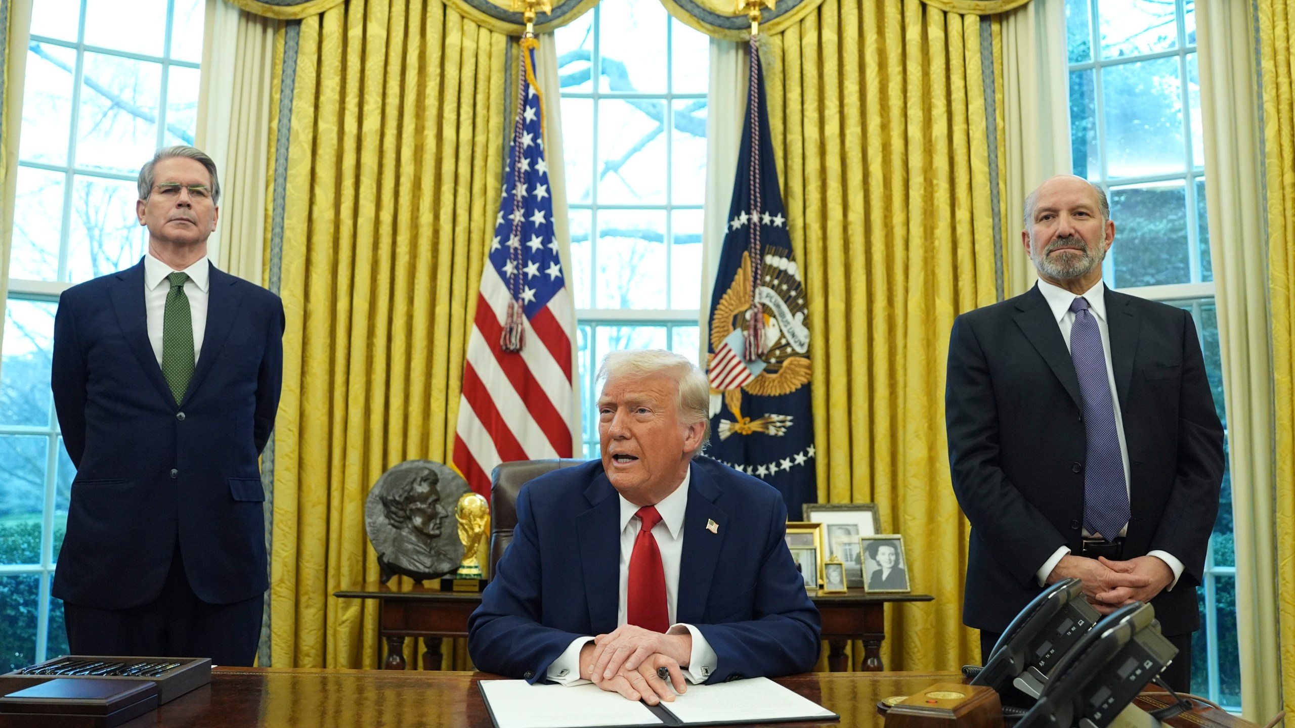 FILE - President Donald Trump speaks as Treasury Secretary Scott Bessent, left, and Commerce Secretary nominee Howard Lutnick, right, listen as Trump prepares to sign an executive order in the Oval Office of the White House, Monday, Feb. 3, 2025, in Washington. (AP Photo/Evan Vucci, File)