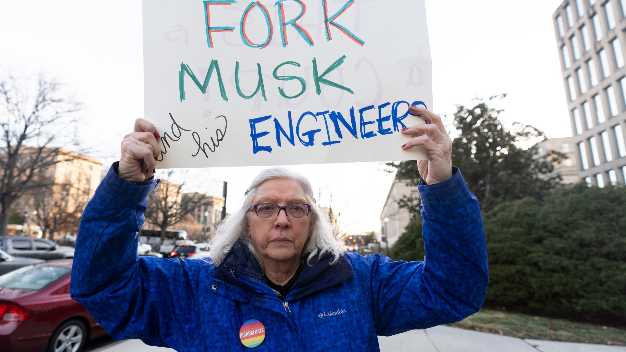Cindy Nell, of Cheverly, Md., holds a banner during a rally in front of the Office of Personnel Management, Monday, Feb. 3, 2025, in Washington. President Donald Trump is relying on a relatively obscure federal agency to reshape government. The Office of Personnel Management was created in 1979 by President Jimmy Carter and is the equivalent of the government's human resources department. It helps manage the civil service, including pay schedules, health insurance and pension programs. The agency has offered millions of federal workers eight months of salary if they voluntarily choose to leave their jobs by Feb. 6. (AP Photo/Manuel Balce Ceneta)