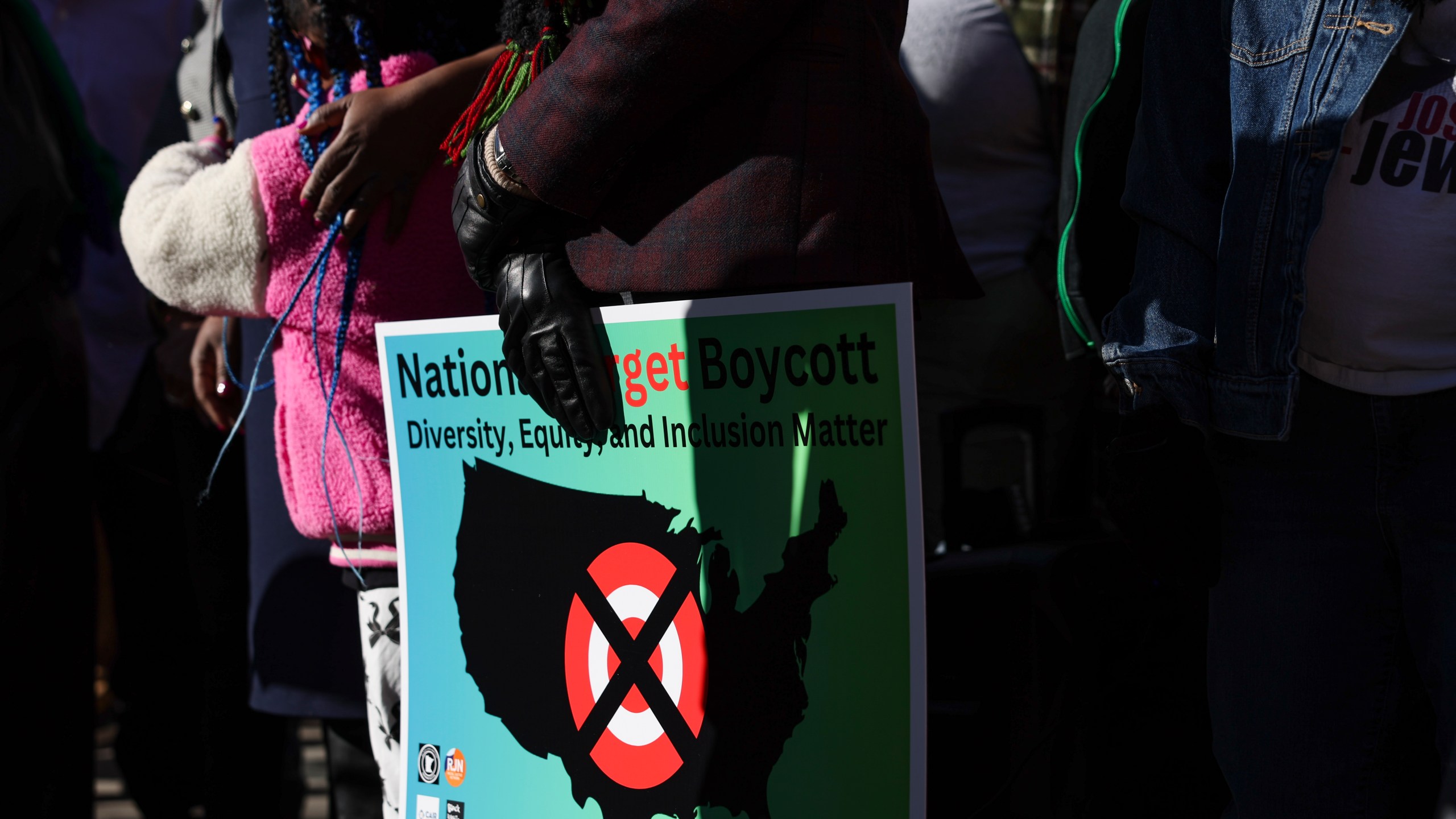 FILE - A community member holds a sign calling for a national boycott of Target stores during a news conference outside Target Corporation's headquarters in Minneapolis, Minn., Jan. 30, 2025. (AP Photo/Ellen Schmidt, File)