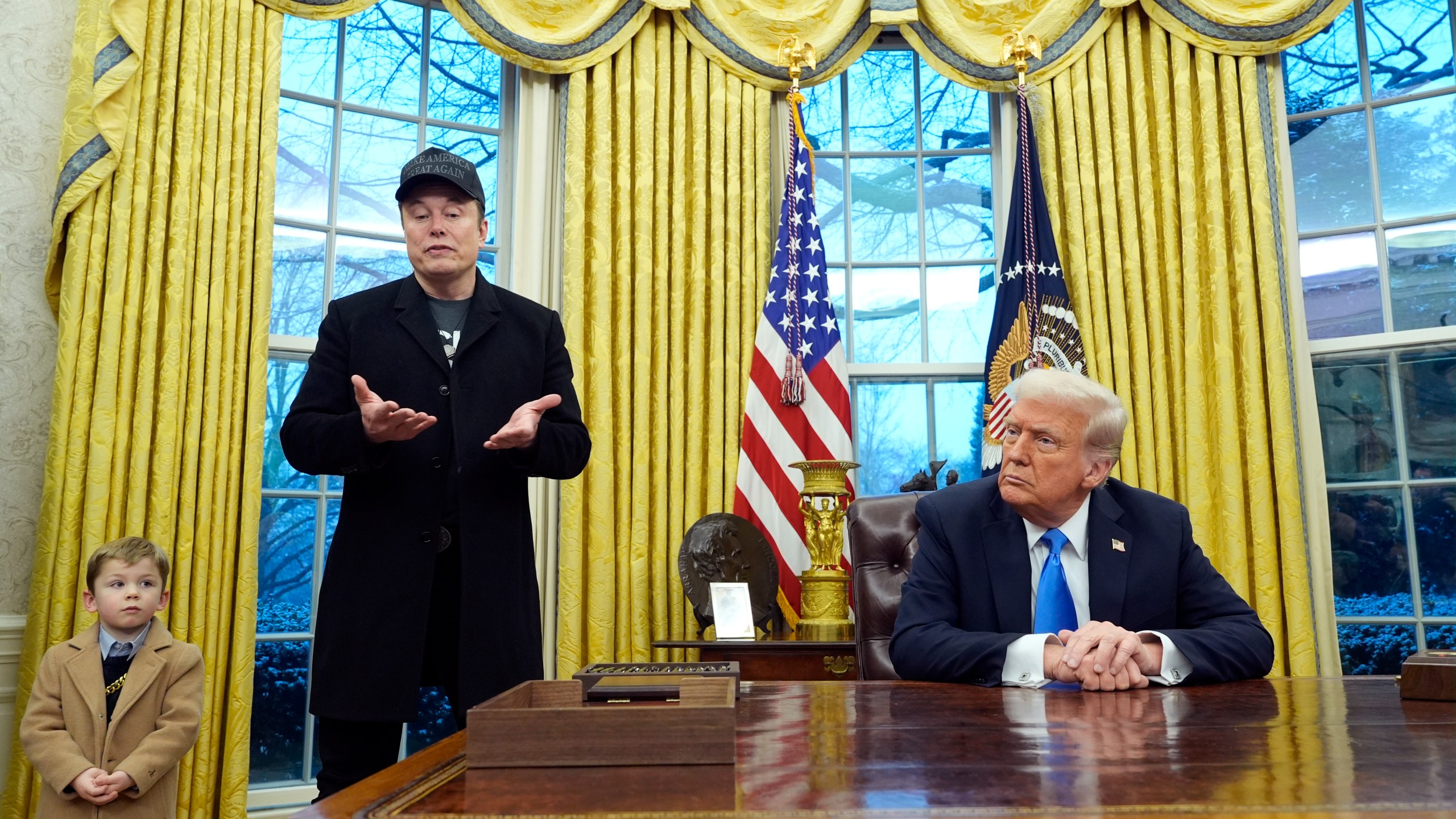 President Donald Trump listens as Elon Musk, joined by his son X Æ A-Xii, speaks in the Oval Office at the White House, Tuesday, Feb. 11, 2025, in Washington. (Photo/Alex Brandon)