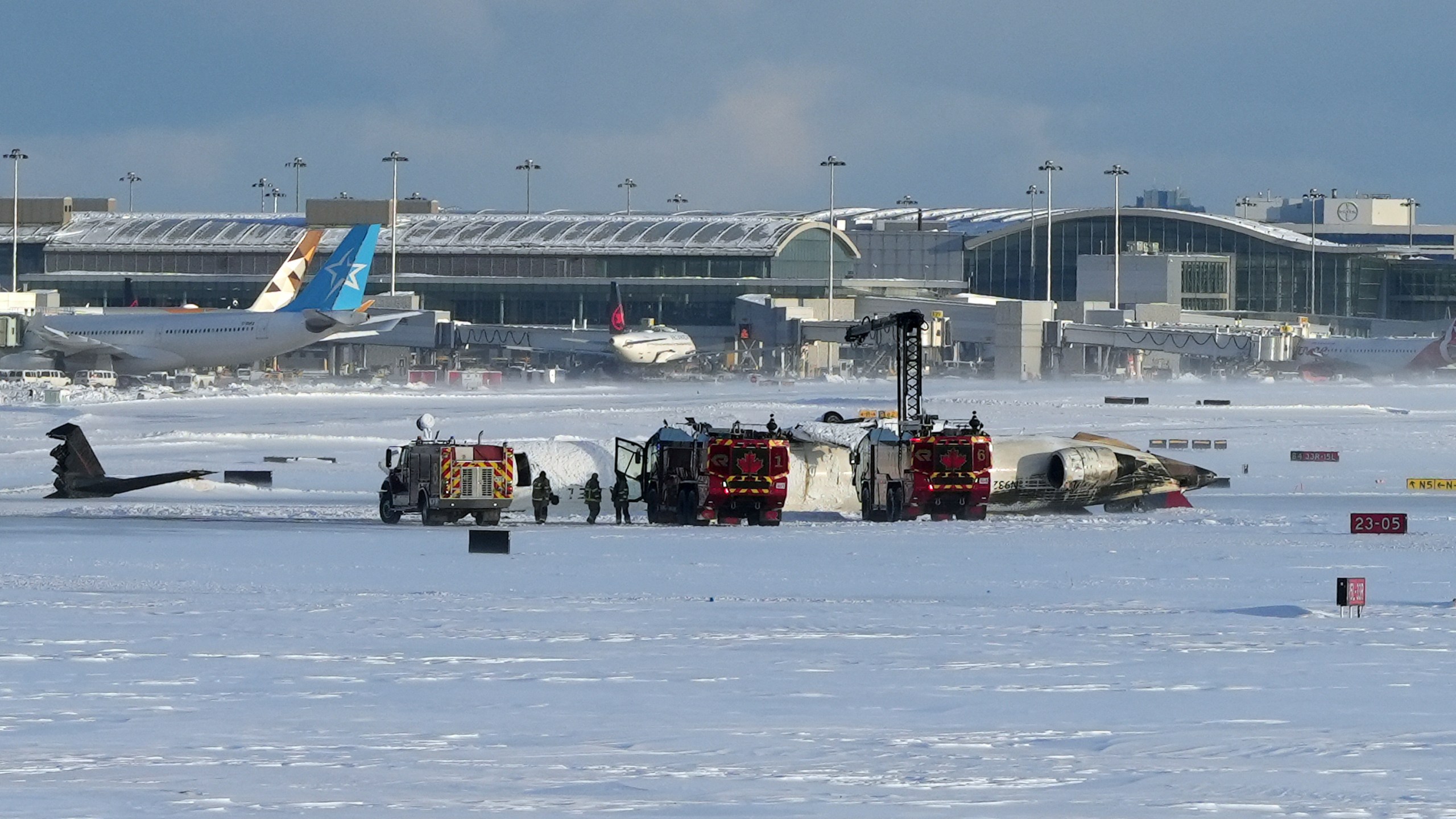 Pearson International Airport firefighters work on an upside down Delta Air Lines plane, which was heading from Minneapolis to Toronto when it crashed on the runway, in Toronto, Monday, Feb. 17, 2025. (Teresa Barbieri/The Canadian Press via AP)
