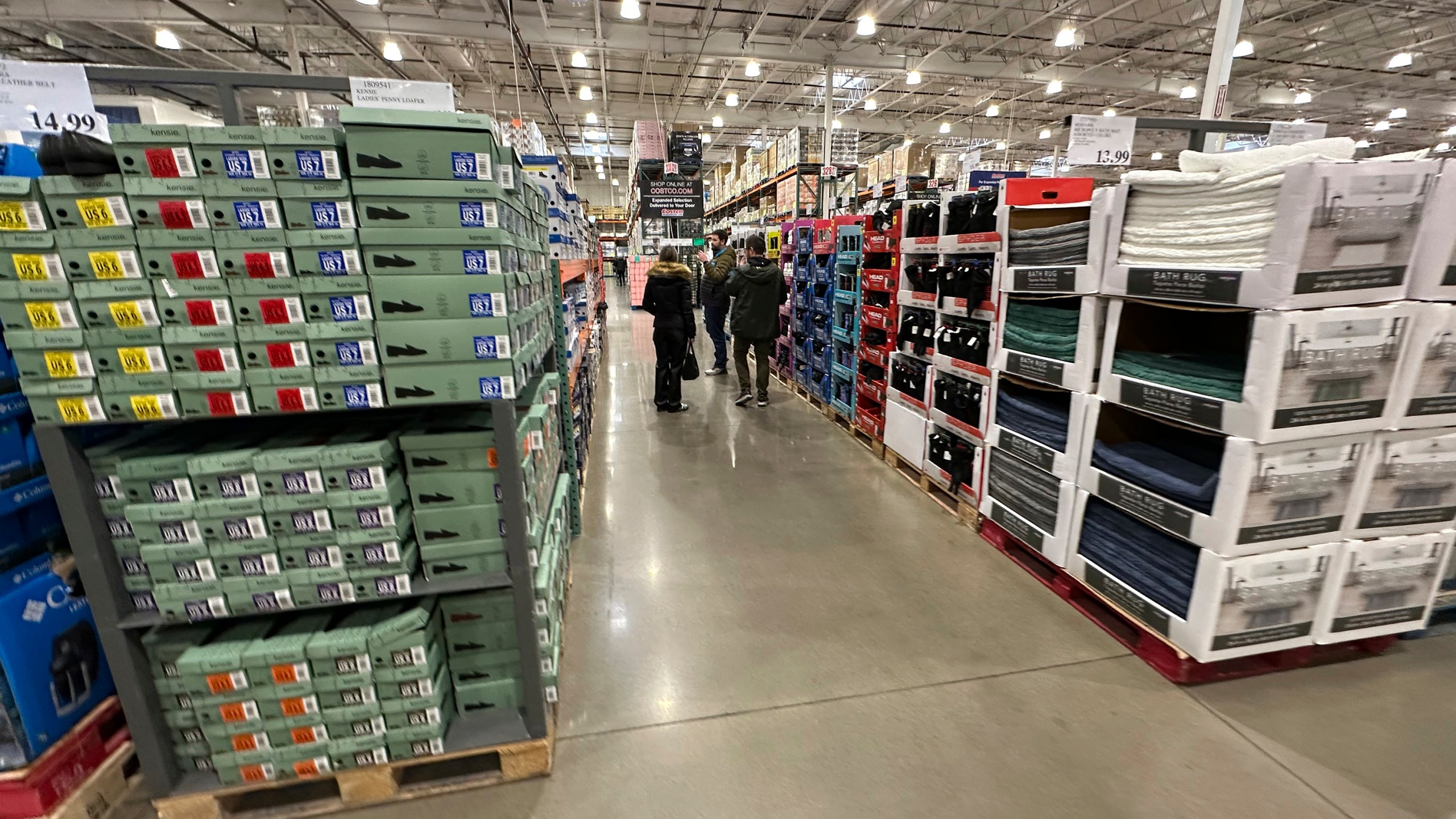 FILE - Shoppers make their ways down an aisle lined with clothing and shoes in a Costco warehouse Thursday, Jan. 23, 2025, in Sheridan, Colo. (AP Photo/David Zalubowski, File)