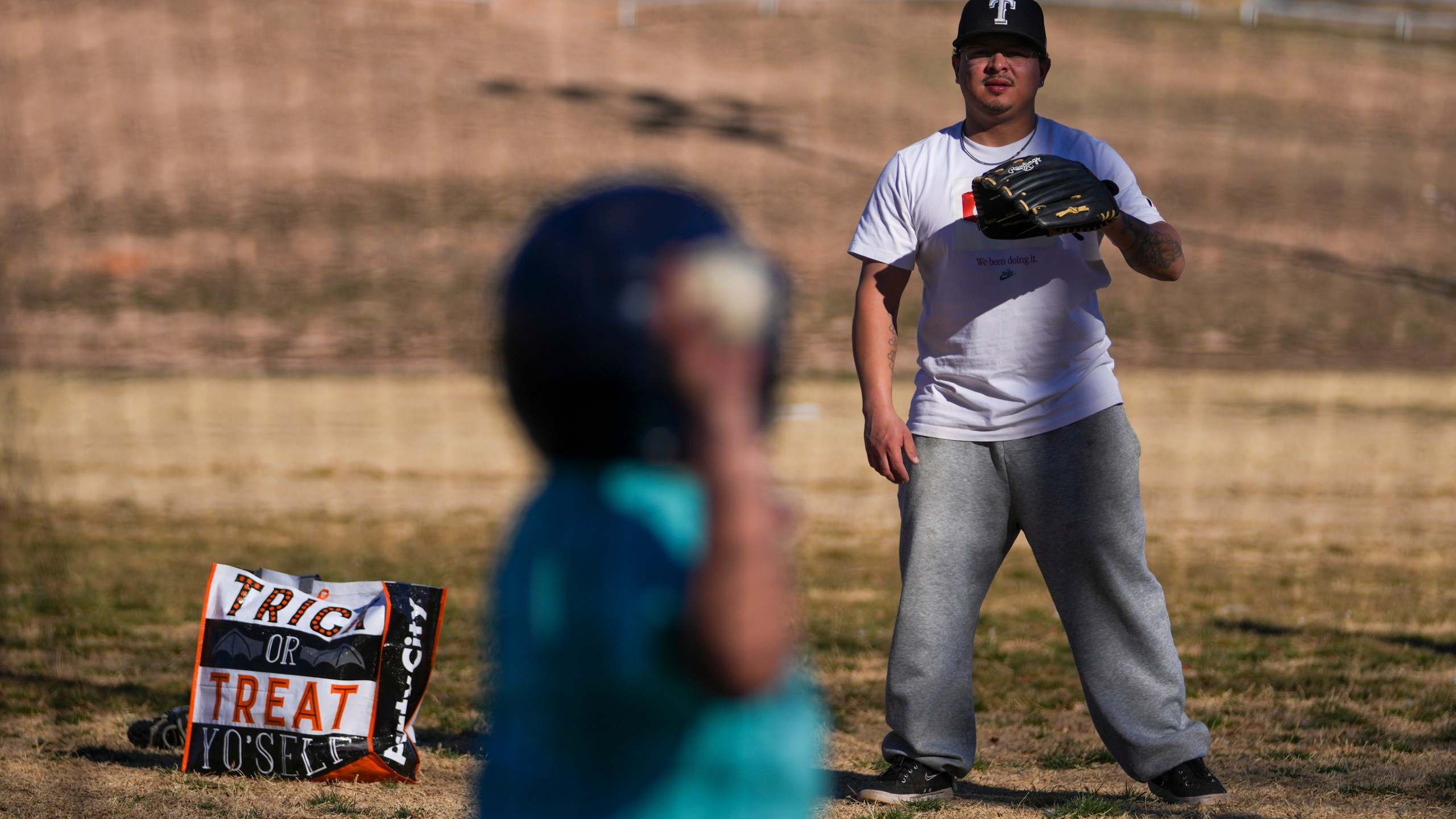 Dylan Cruz, 28, works on baseball batting skills with his son Jeremyah Cruz, 9, at Coleman Park Sunday, Feb. 23, 2025, in Brownfield, Texas. (AP Photo/Julio Cortez)