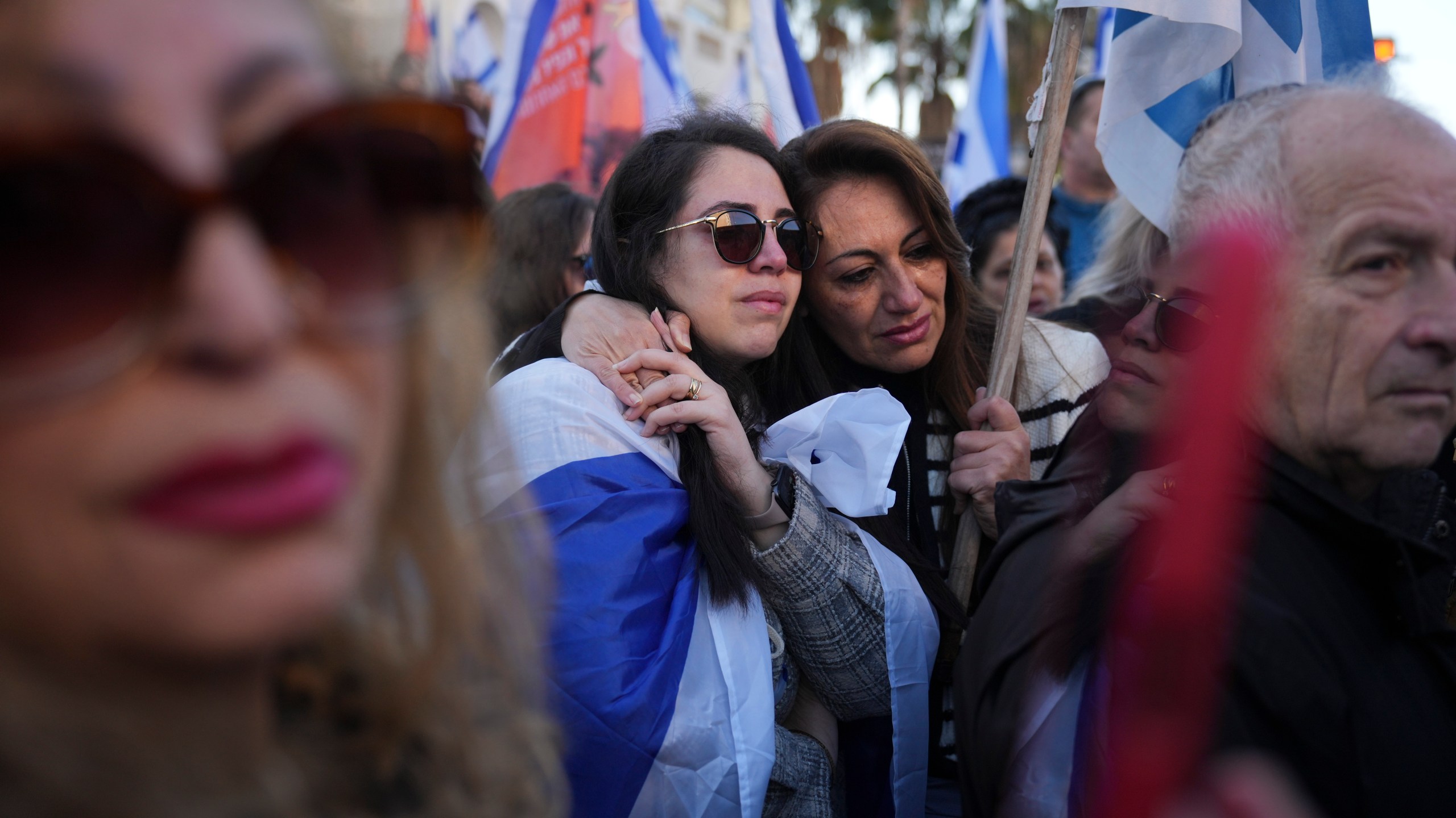 Mourners react as the convoy carrying the coffins of slain hostages Shiri Bibas and her two children, Ariel and Kfir, passes by during their funeral procession in Rishon Lezion, Israel, Wednesday, Feb. 26, 2025. The mother and her two children were abducted by Hamas on Oct. 7, 2023, and their remains were returned from Gaza to Israel last week as part of a ceasefire agreement with Hamas. (AP Photo/Ariel Schalit)