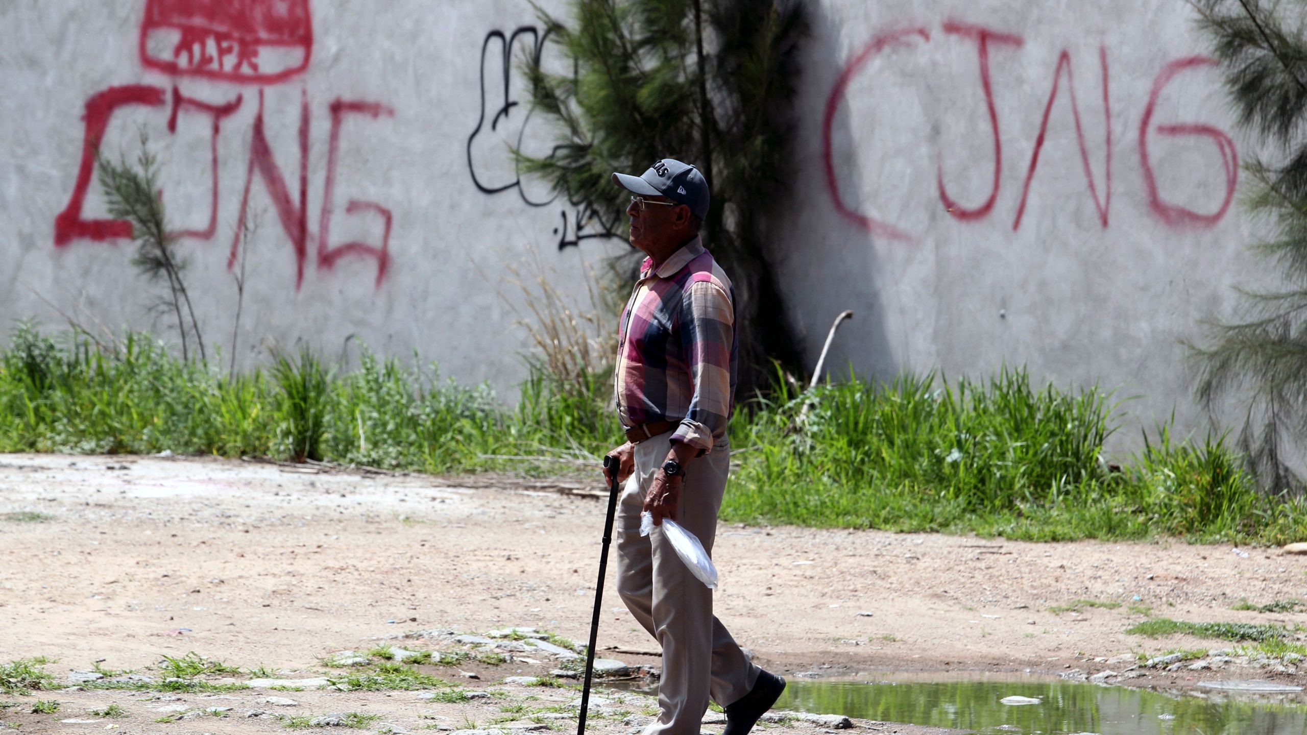 The initials of the drug cartel "Jalisco Nueva Generacion" (CJNG) are seen in graffiti on a wall