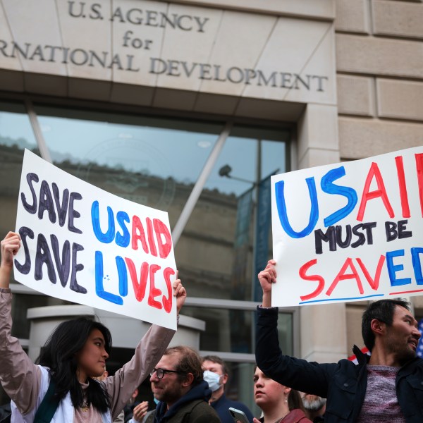 Protesters holding signs in support of USAID