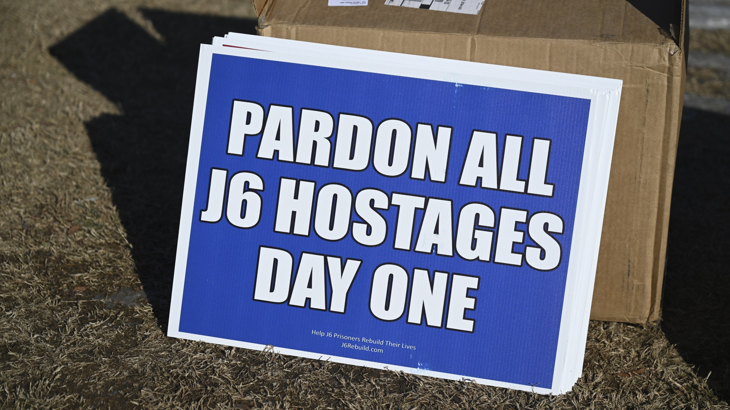 signs that says 'Pardon all J6 hostages day one'