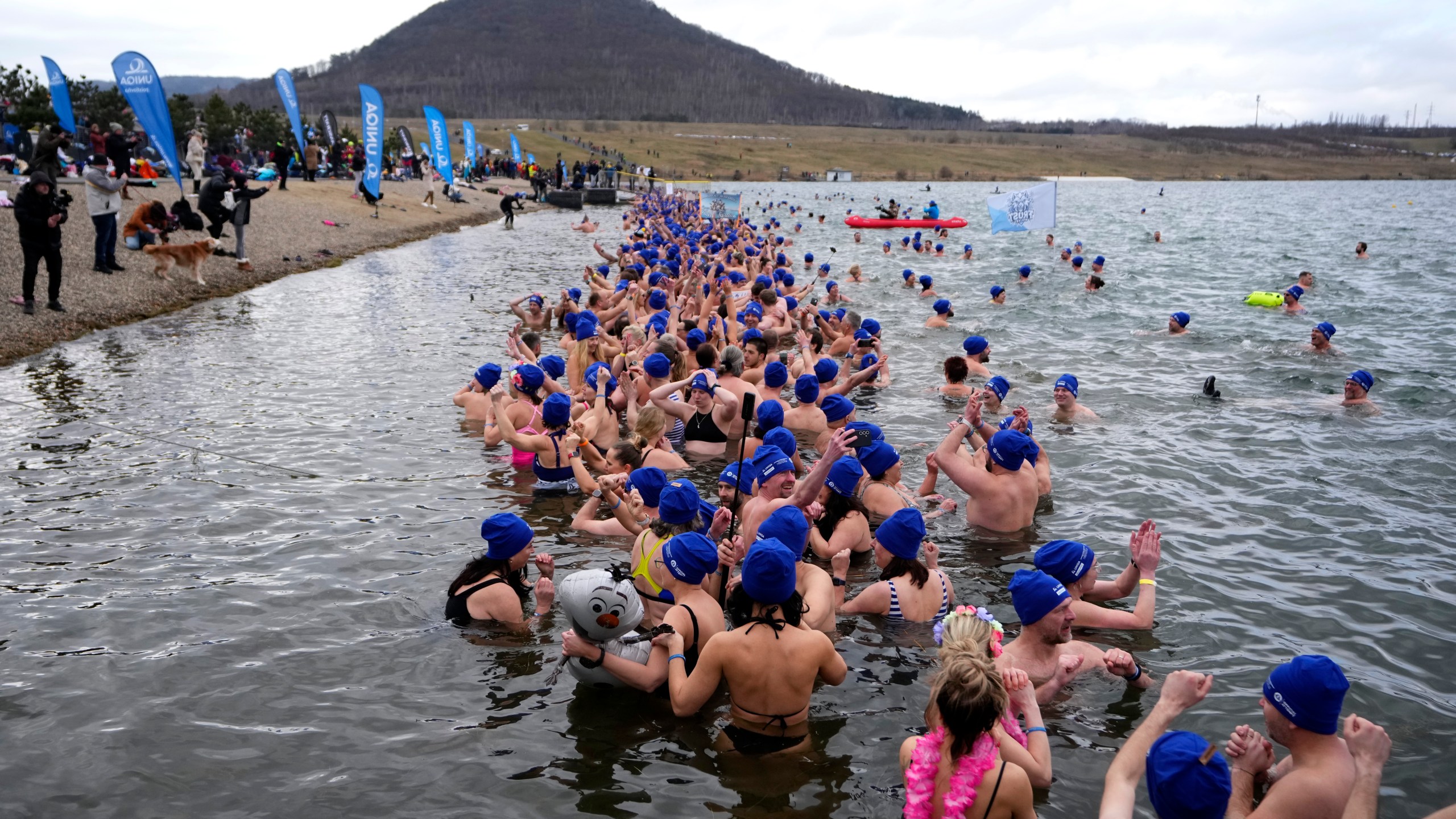 Some of 2461 polar swimmers wait in the water to set a world record for the largest polar bear dip at a lake in Most, Czech Republic, Saturday, March 1, 2025. (AP Photo/Petr David Josek)