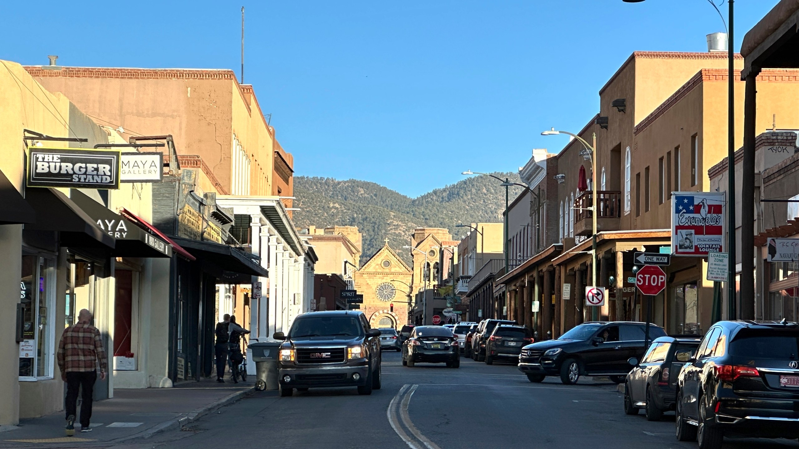 The sun begins to set as vehicles make their way through a historic district in downtown Santa Fe, New Mexico, on Thursday, Feb. 27, 2025. (AP Photo/Susan Montoya Bryan)
