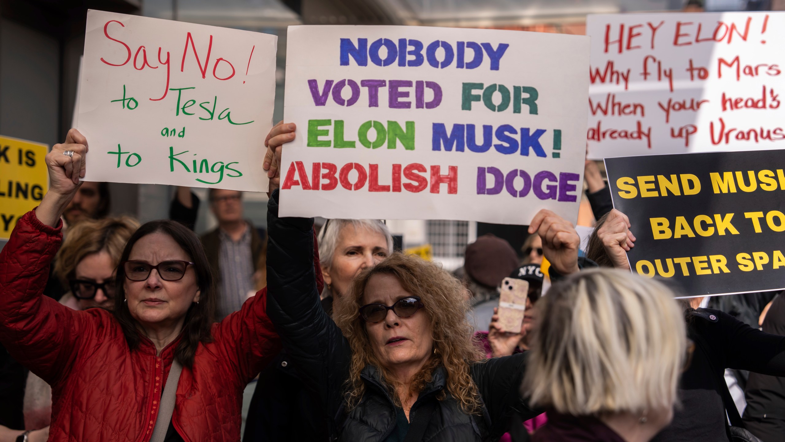 Demonstrators take part in a protest against Elon Musk and Tesla outside of a Tesla showroom, Saturday, March 01, 2025 in New York. (AP Photo/Adam Gray)