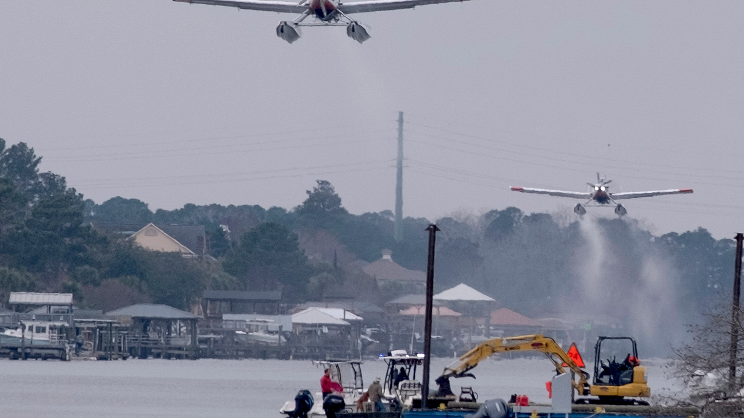 Planes fill bladders with water from the Intracoastal Waterway and empty the water on hot spots in the Carolina Forest wildfire Sunday, March 2, 2025, in Myrtle Beach, S.C. (Janet Morgan/The Post And Courier via AP)