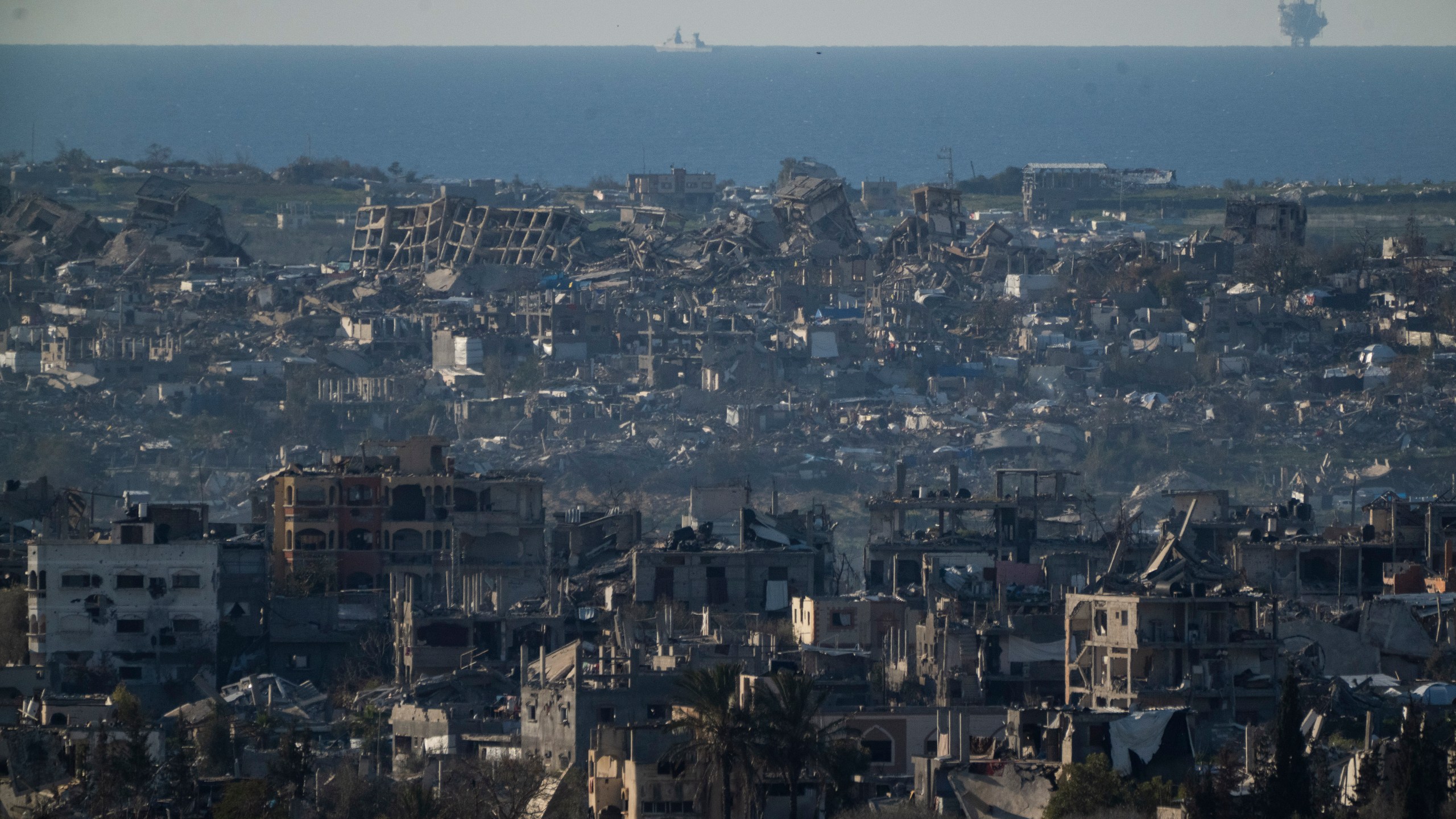 Buildings destroyed during the Israeli air and ground offensive stand in the Gaza Strip are seen from southern Israel, Sunday, March 2, 2025. (AP Photo/Leo Correa)