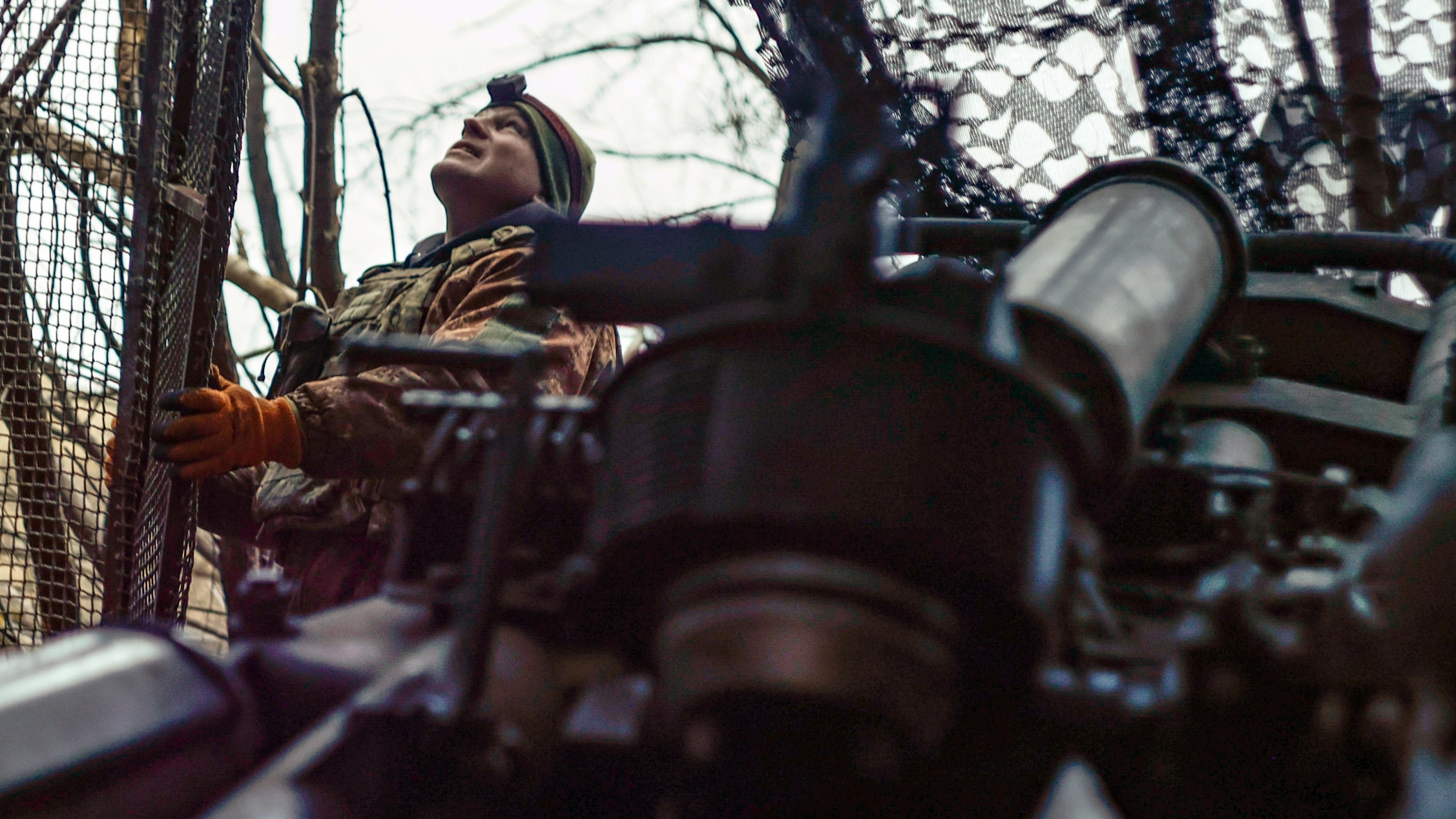 A Ukrainian soldier looks at the sky searching for Russian FPV drones as he gets ready to fire a M777 howitzer towards Russian positions at the frontline near Donetsk, Ukraine, Monday, March 3, 2025. (AP Photo/Roman Chop)