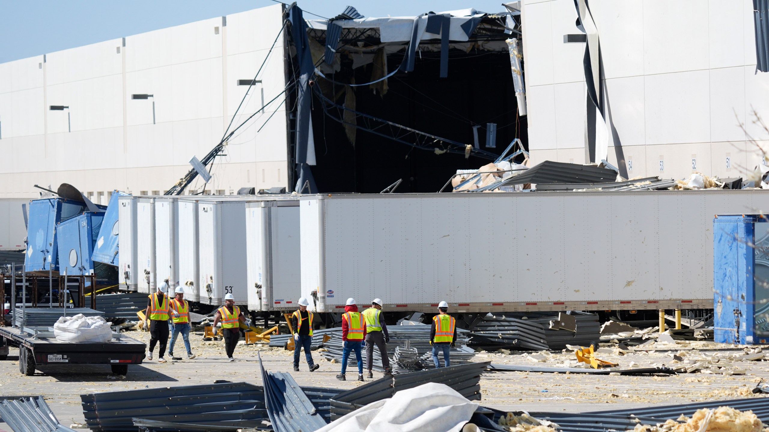 A workers walk outside a damaged warehouse after storms moved through Tuesday, March 4, 2025, in Lewisville, Texas. (AP Photo/LM Otero)