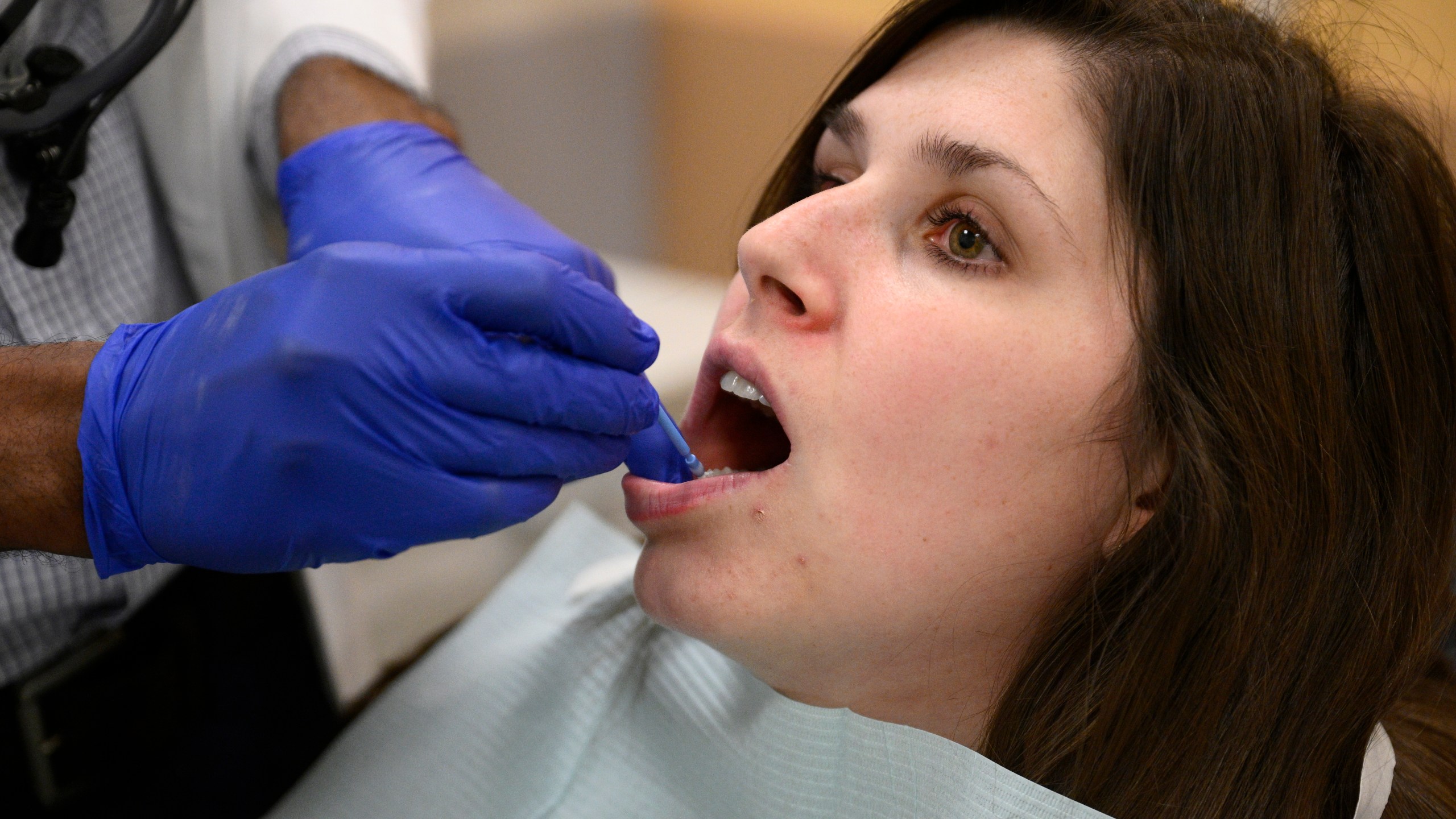 Alexander Daniel, DDS, left, demonstrates fluoride treatment on resident Cameron Onken, right, at the Johns Hopkins Outpatient Center, Friday, Feb. 28, 2025, in Baltimore. (AP Photo/Nick Wass)