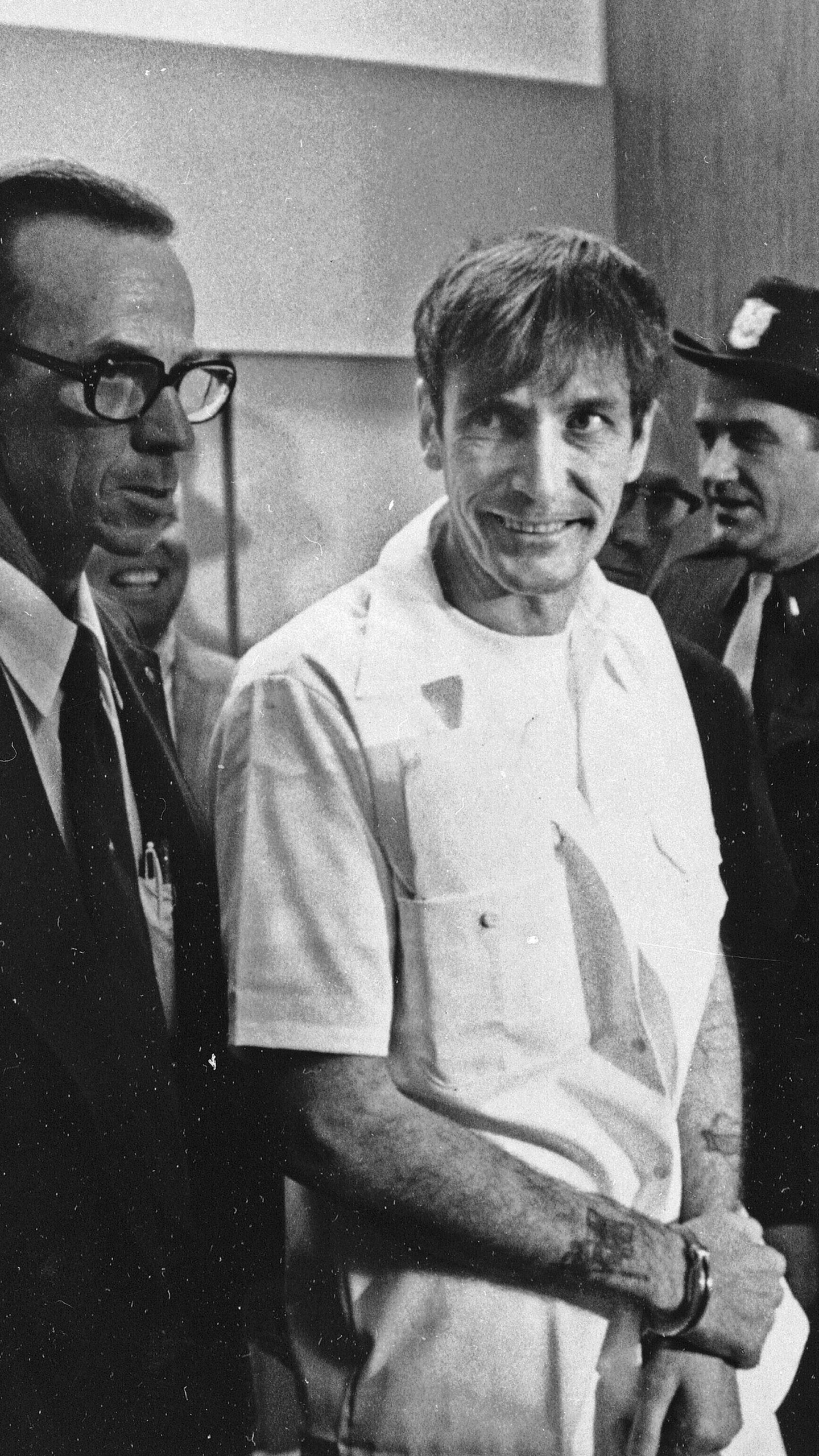 FILE - Convicted murderer Gary Mark Gilmore arrives, heavily guarded, at the 4th District Court in Provo, Utah, on Dec. 1, 1976. (AP Photo/Ron Barker, File)