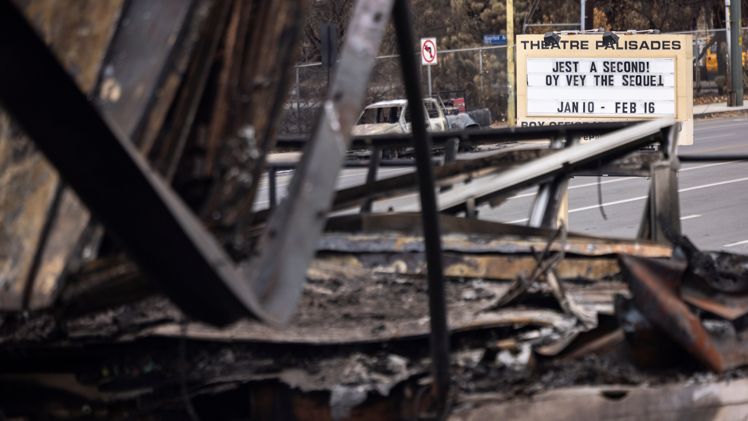 A billboard reads "Theatre Palisades" next to a destroyed building