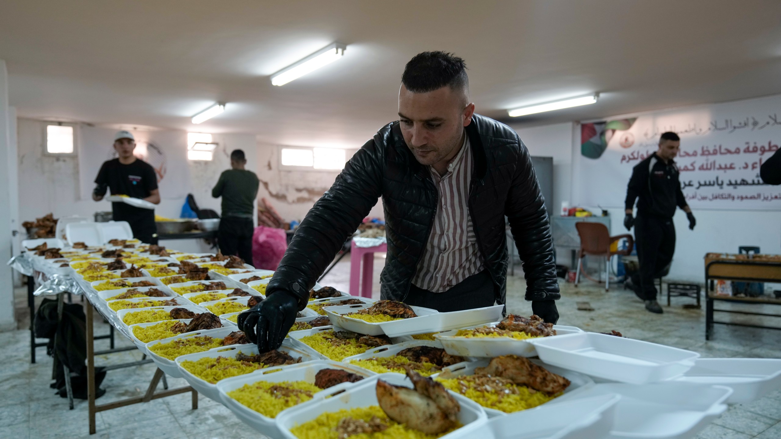 Volunteers at the Yasser Arafat Charity Kitchen in Tulkarem, West Bank, prepare an iftar meal for displaced Palestinians trying to mark the Muslim holy month of Ramadan on Monday, March 3, 2025. (AP Photo/Majdi Mohammed)