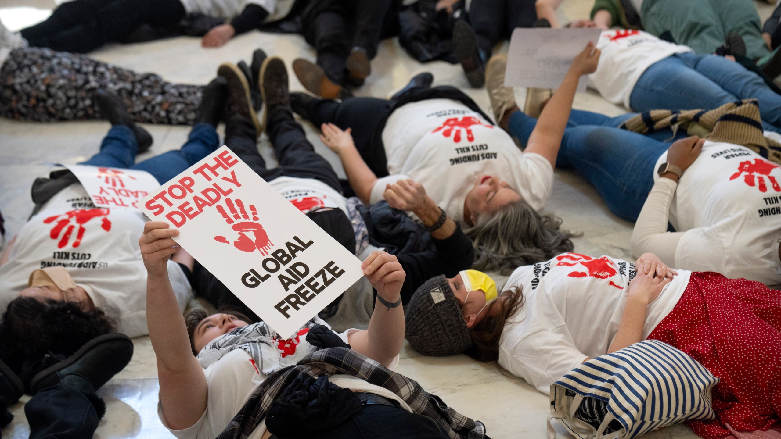 FILE - Demonstrators protest against cuts to American foreign aid spending, including USAID and the PEPFAR program to combat HIV/AIDS, at the Cannon House Office Building on Capitol Hill, Feb. 26, 2025, in Washington. (AP Photo/Mark Schiefelbein, file)