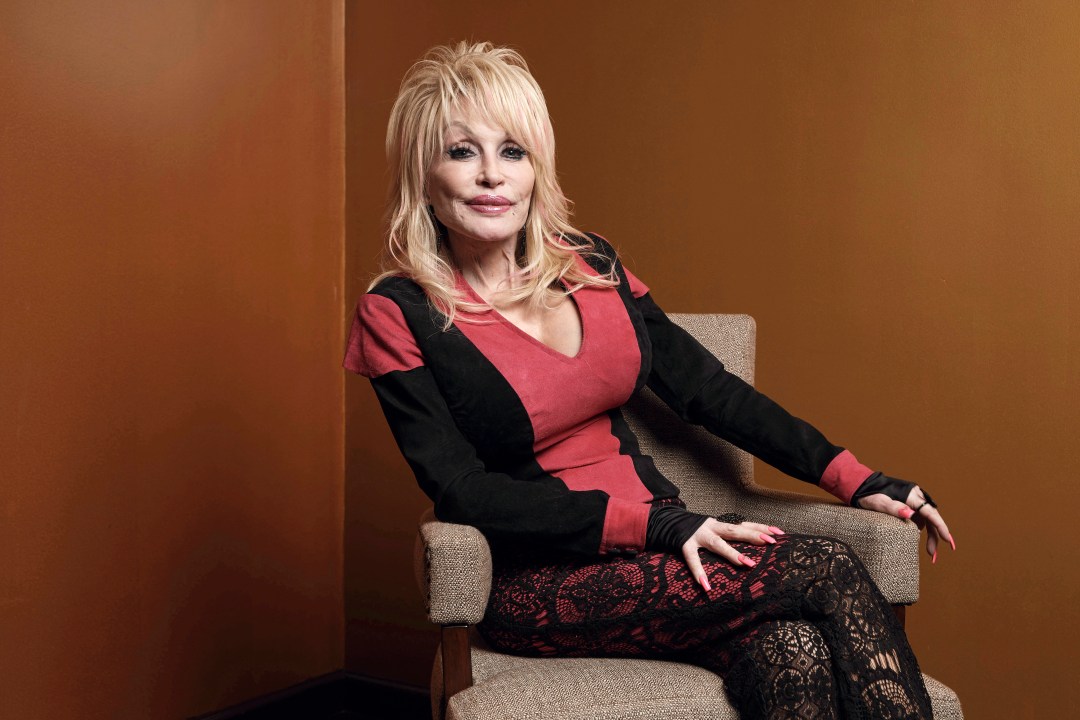 Dolly Parton poses on a chair