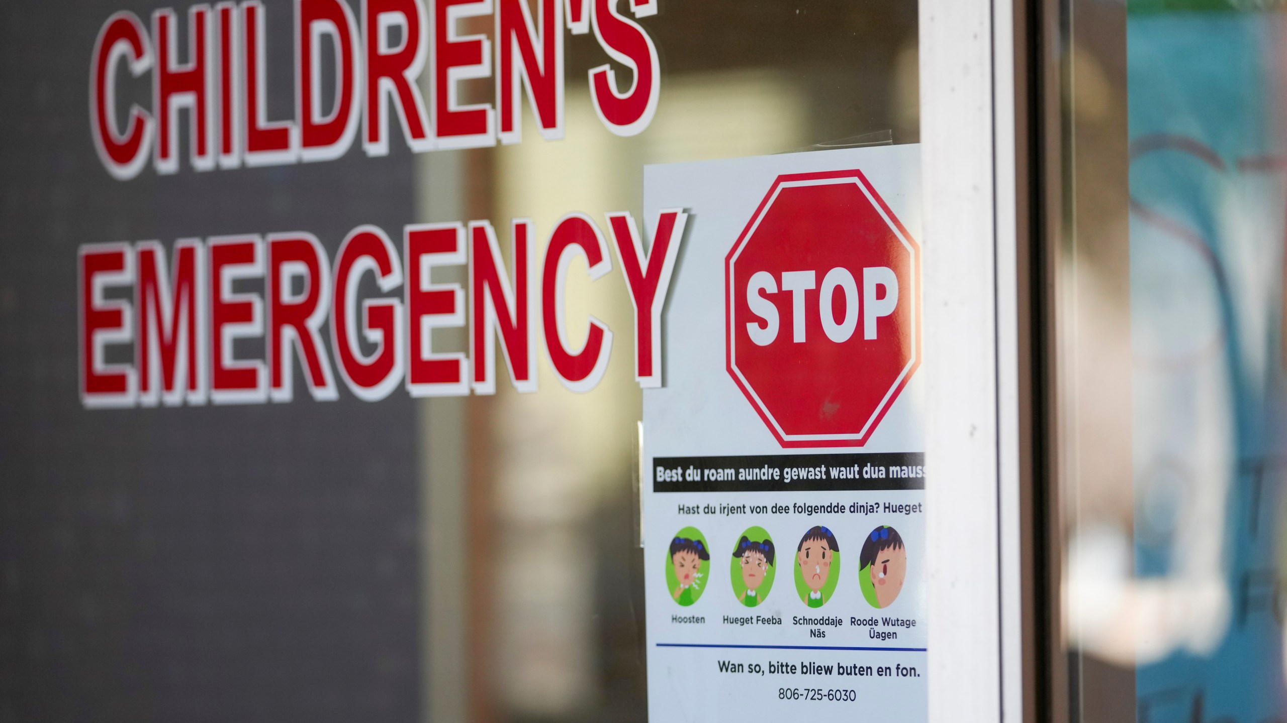 A sign is posted in German at the entrance of the children's emergency room at Covenant Children's Hospital, Tuesday, Feb. 25, 2025, in Lubbock, Texas. (AP Photo/Julio Cortez)